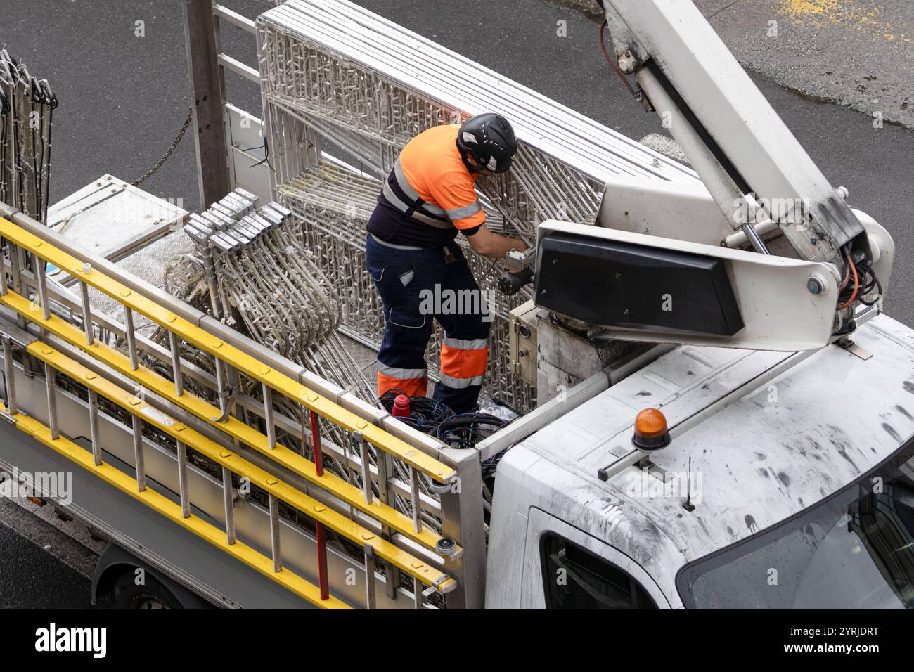 Elektriker bereitet weihnachtsbeleuchtung für den Einbau in die Stadtstraße mit einem Kranwagen vor Stockfoto