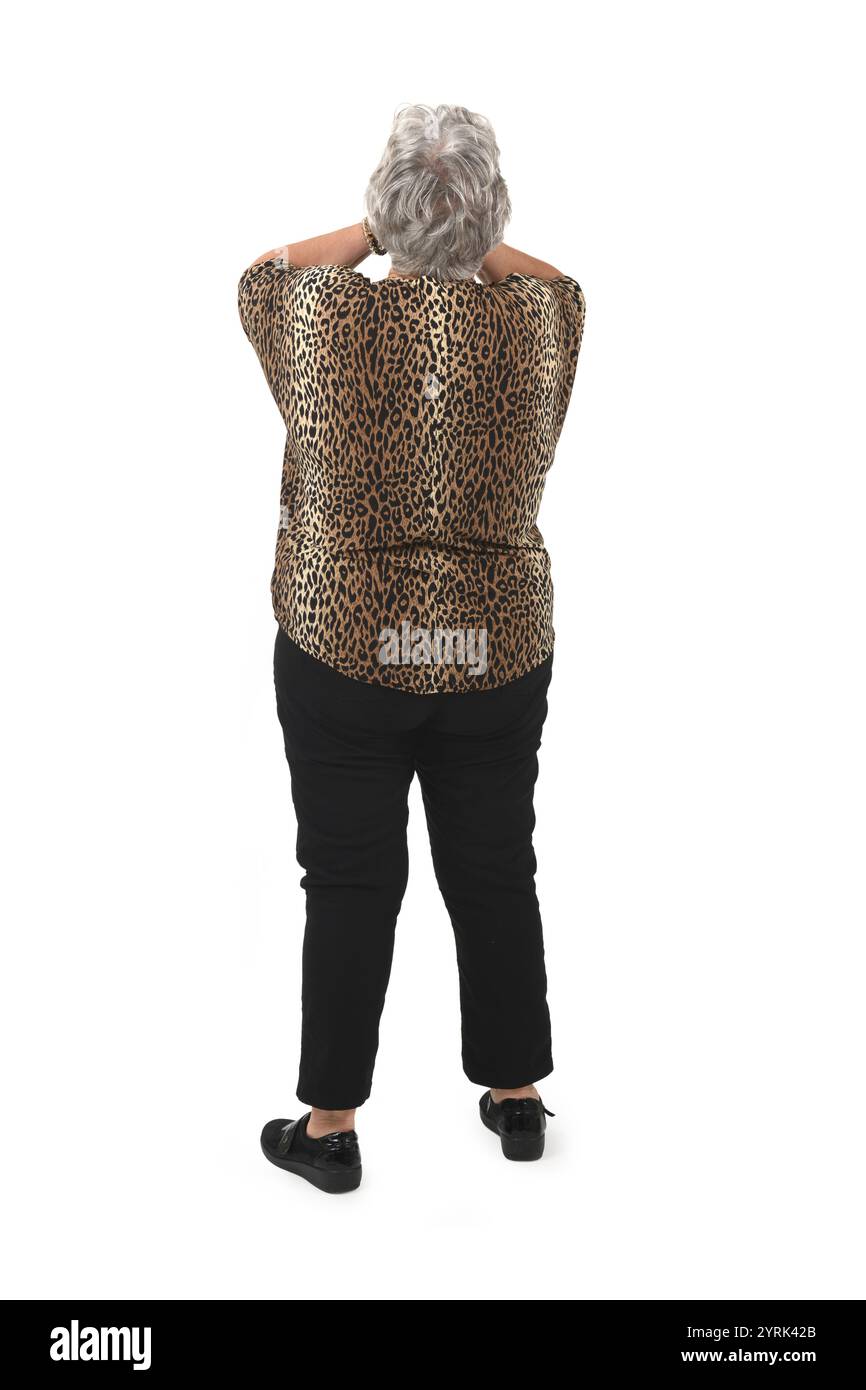 Rückansicht einer älteren Frau, die ihr Gesicht mit ihrem Arm auf weißem Hintergrund bedeckt Stockfoto
