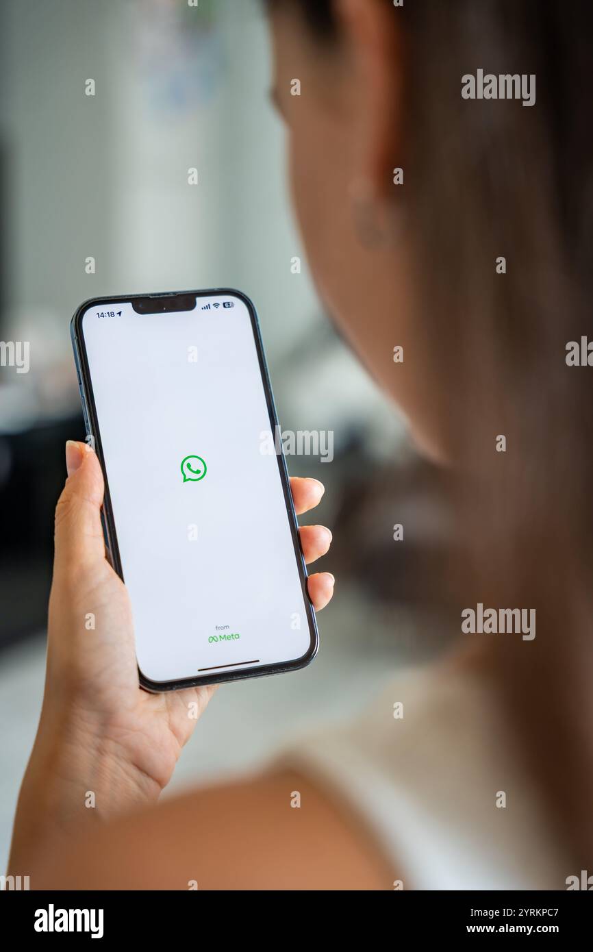 Prag, Tschechische republik - 2. Mai 2024: Frau hält iPhone mit Chat-Anwendung WhatsApp auf dem Bildschirm, die mobile Anwendung für das Business Home verwendet Stockfoto