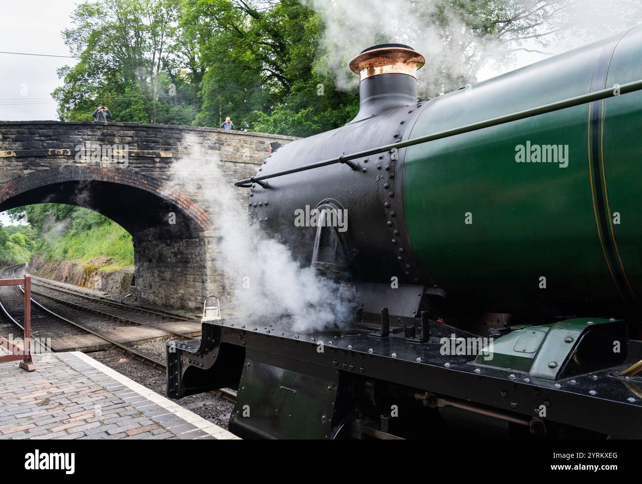 Severn Valley Railway, Arley, Worcestershire, 16-06-2019. Der klassische Zug, der Bristolian 473, lässt Dampf ab, während Touristen von der Straße aus schnappen Stockfoto