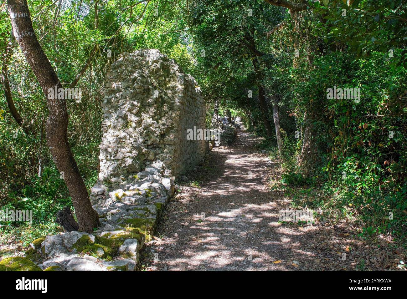 Ein Pfad und alte Steinmauern im Butrint Archaeological Park, im Butrint National Park, Südalbanien. Ein UNESCO-Weltkulturerbe. Stockfoto