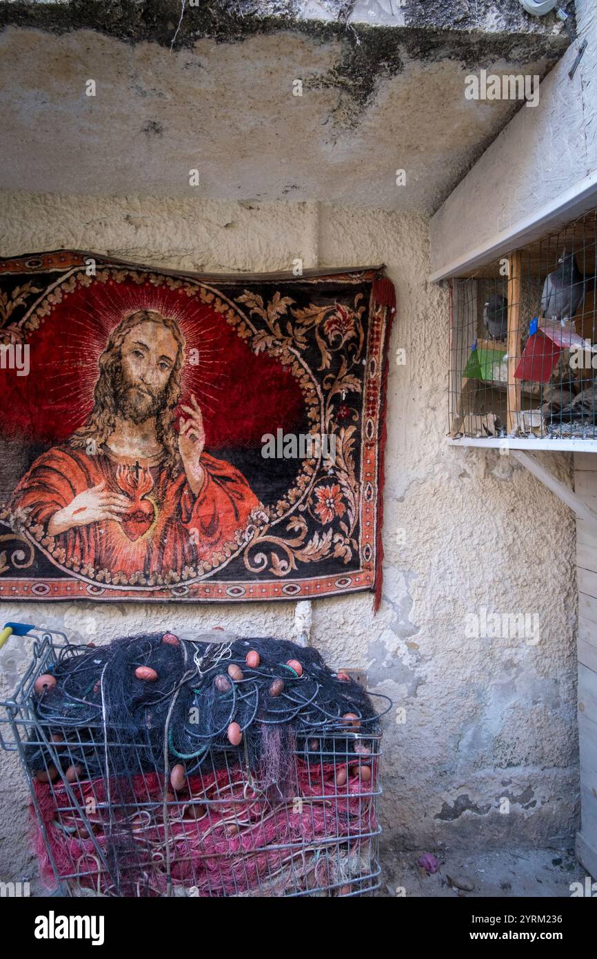 Fischerhaus in Ortigia, Sizilien, Italien, mit Trolley gefüllt mit Netzen, religiöser Kunst und Taubenloft Stockfoto