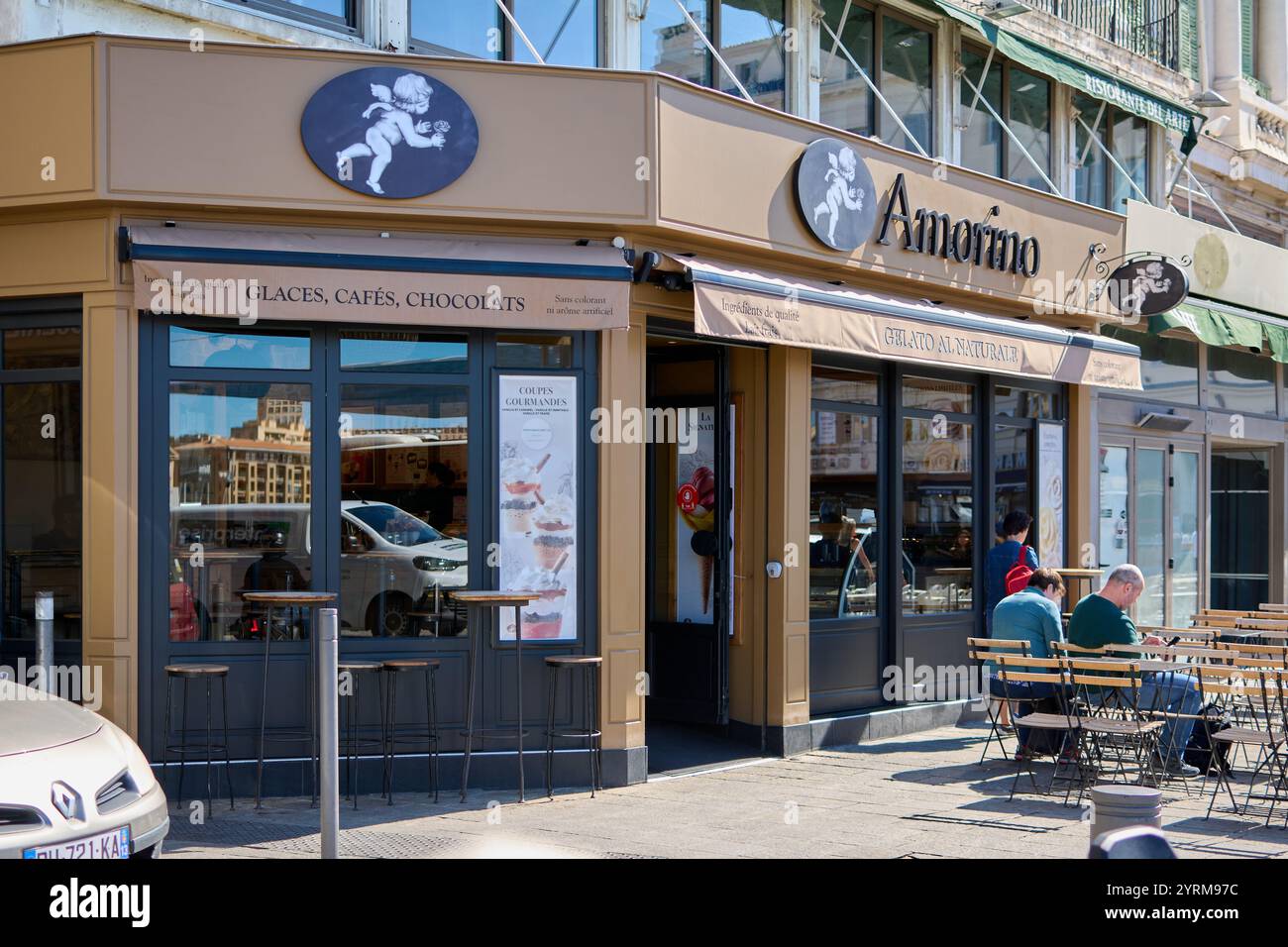 Marseille. Frankreich - 4. Dezember 2024: Gäste entspannen sich vor Amorino Gelato Coffee und genießen ihre Desserts. Die Beschilderung und das Branding des Ladens sind sehr hoch Stockfoto