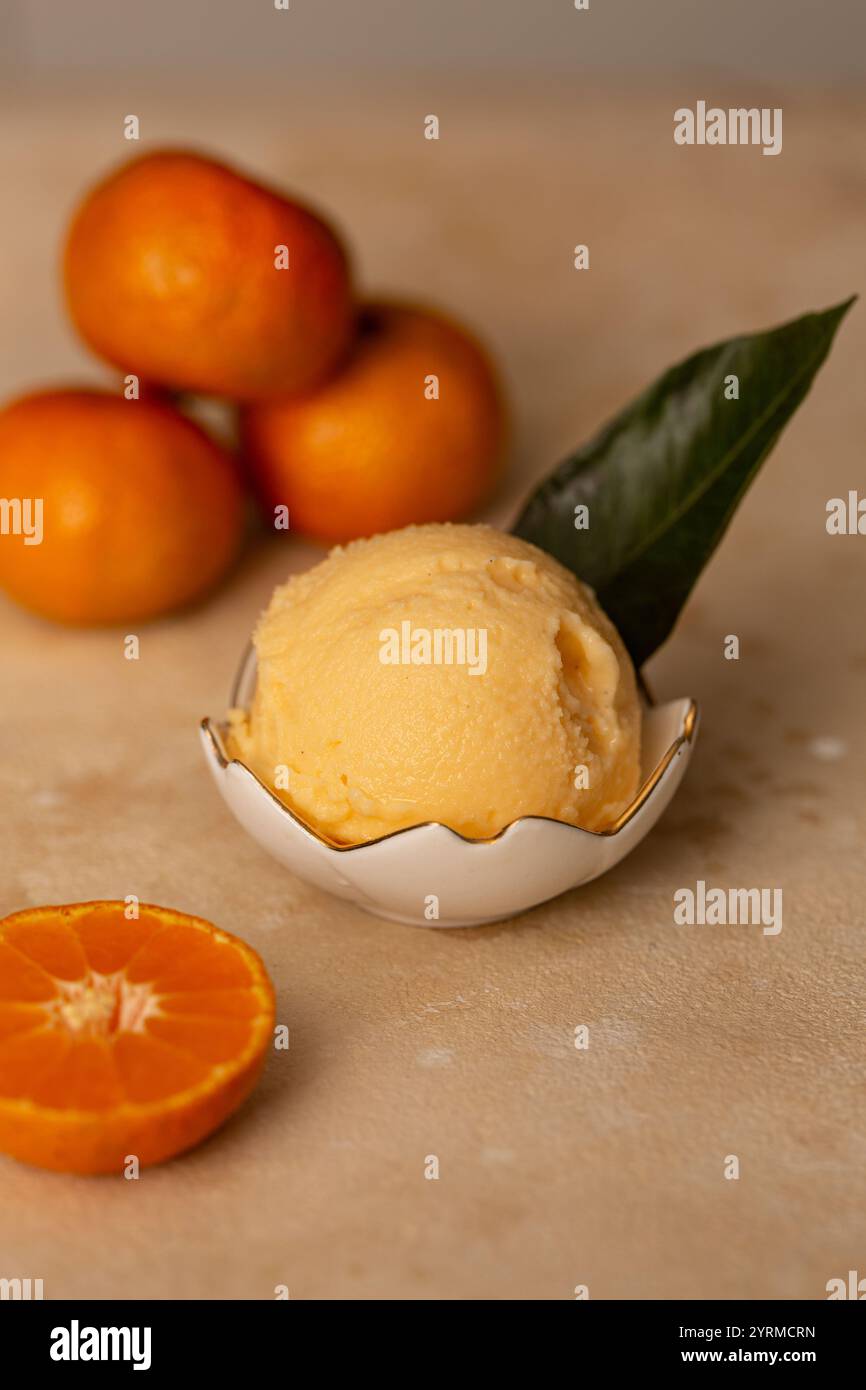 Eine Kugel Mandarineneis in einem Milchkännchen Stockfoto
