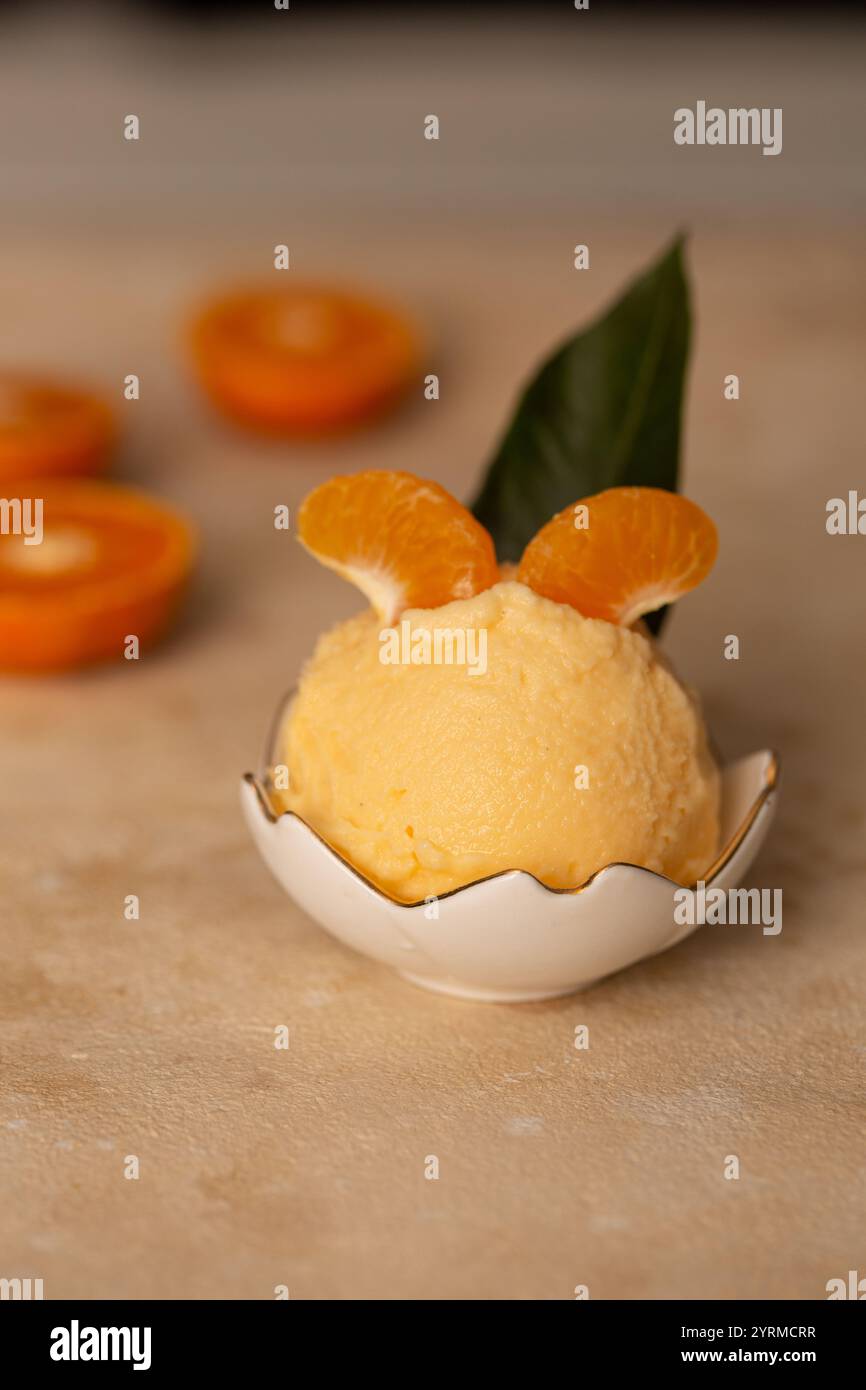 Eine Kugel Mandarineneis in einem Milchkännchen Stockfoto