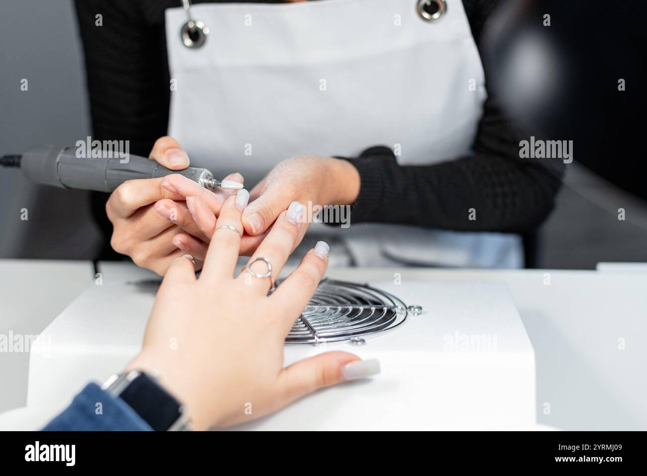 Frau professionelle Manikürerin, die Maniküre im Schönheitssalon macht. Mädchen, das Nagelpflege macht Stockfoto