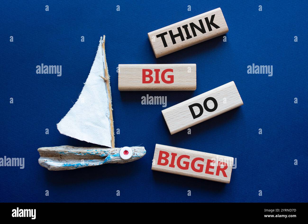 Denken Sie an großes, größeres Symbol. Holzblöcke mit Worten denken, Big machen größer. Wunderschöner tiefblauer Hintergrund mit Boot. Business und Think Big können größer werden. Stockfoto