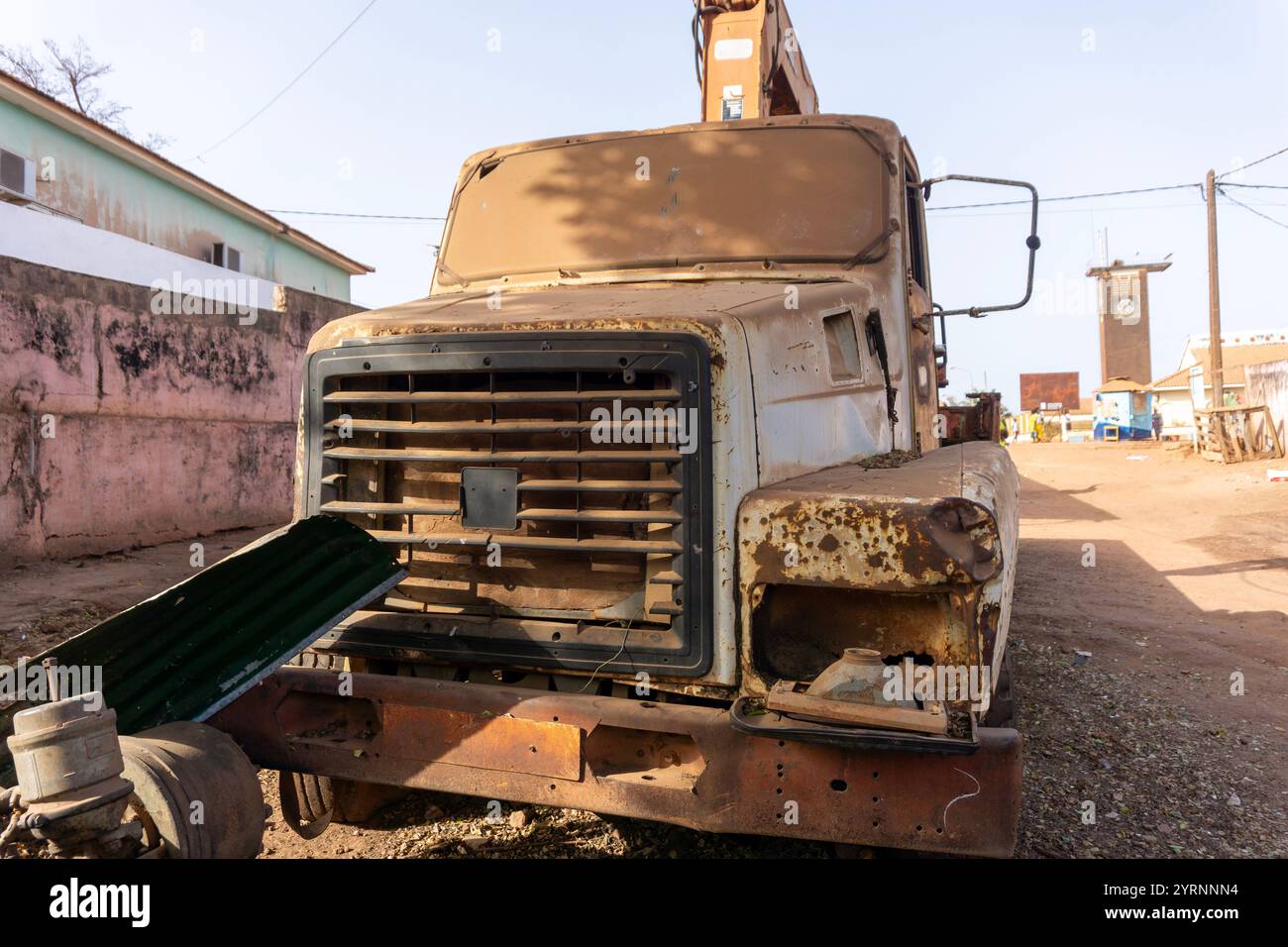 Verlassener Kranwagen im afrikanischen Dorf. Ein Niedrigwinkelschuss eines verwitterten oder baufälligen LKW-Krans. Windschutzscheibe durch Sand undurchsichtig Stockfoto