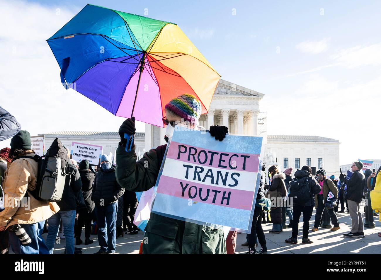 Washington, District of Columbia, USA. Dezember 2024. Eine Person mit einem Regenbogenschirm und einem Schild mit der Aufschrift „Protect TransYouth“ bei einer Demonstration gegen ein Gesetz in Tennessee, das Puberty Blocker und Hormontherapie für Transgender-Teenager verbietet, das heute vor dem Obersten Gerichtshof in Washington, DC diskutiert wird. (Credit Image: © Michael Brochstein/ZUMA Press Wire) NUR REDAKTIONELLE VERWENDUNG! Nicht für kommerzielle ZWECKE! Stockfoto