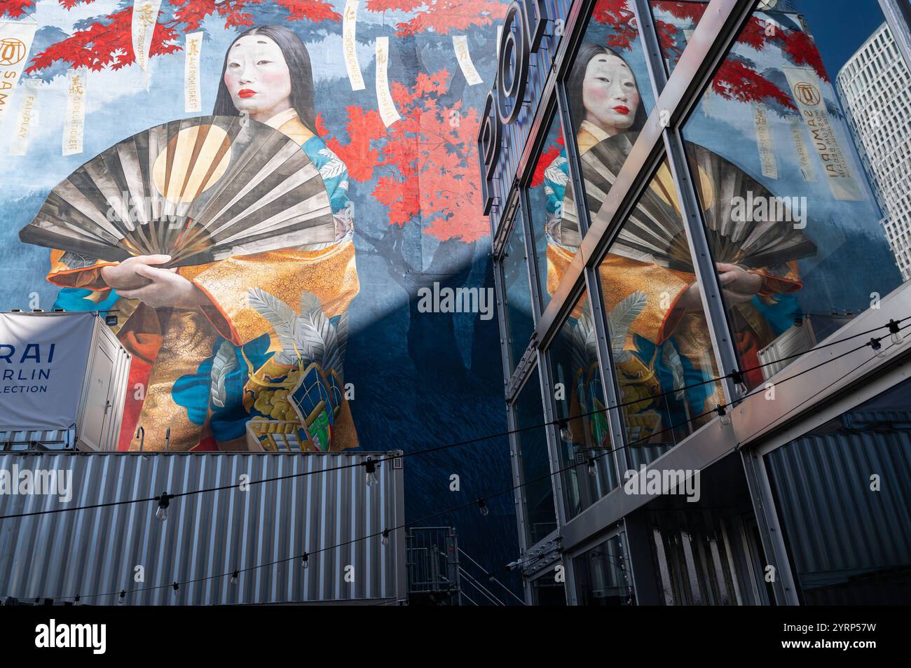 02.09.2024, Berlin, Deutschland, Europa - das bunte Wandbild einer japanischen Geisha mit einem Papierfaecher spiegelt sich in der Glasscheibe eines Gebaeudes am Kurfürstendamm in der City West im Berliner Bezirk Charlottenburg. Das Wandgemaelde Namens Fair Play - die 7 Tugenden des Bushido, ist ein Gemaelde der Kuenstlerin Anna taut nach einer Fotografie von Sylwia Makris, zum Anlass der 30 Jahre Staedtepartnerschaft zwischen Berlin und Tokio. *** 02 09 2024, Berlin, Deutschland, Europa das bunte Wandbild einer japanischen Geisha mit Papierfächer spiegelt sich in der Glasscheibe eines Gebäudes auf Kurfu wider Stockfoto