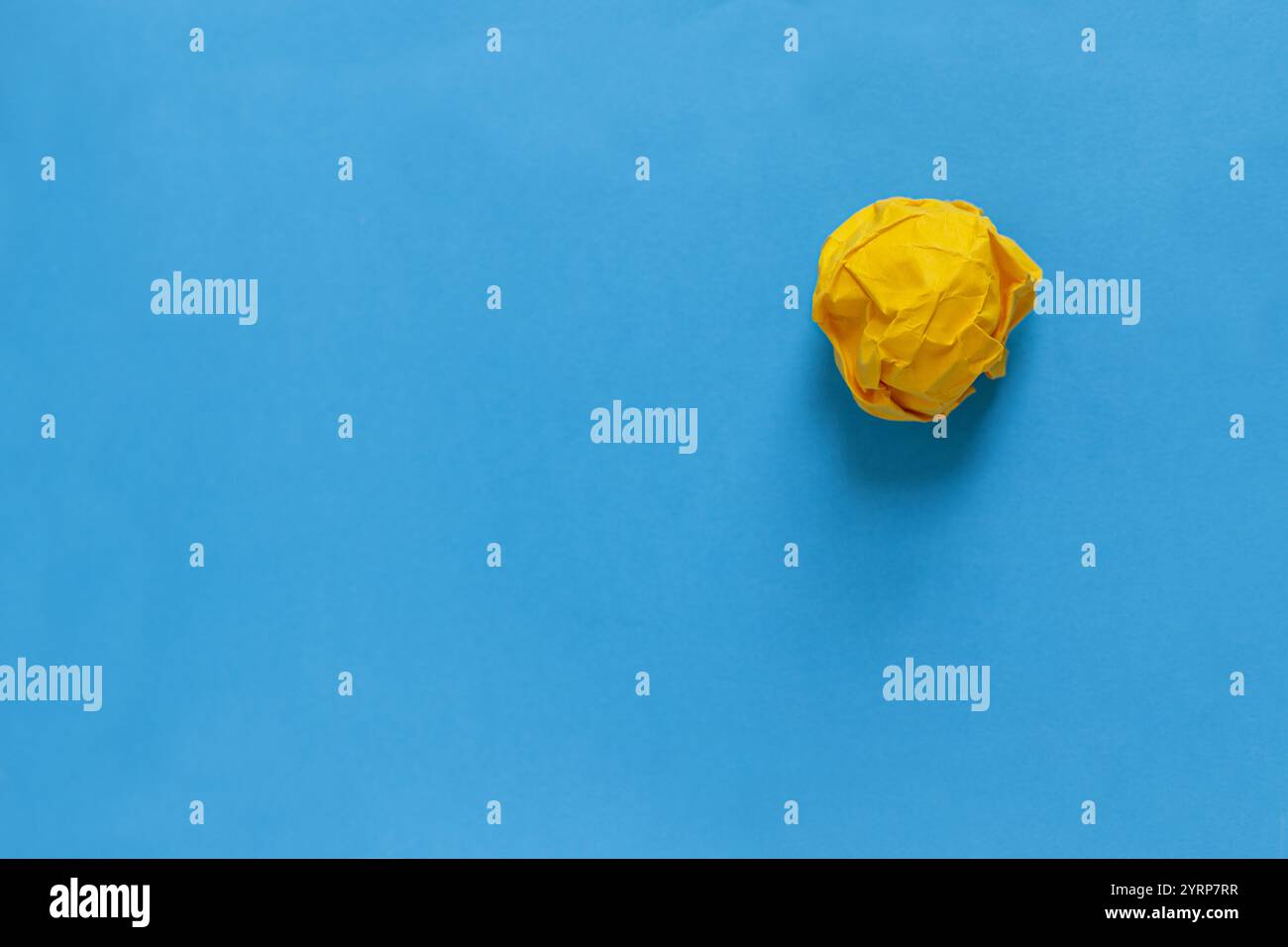 Gelbes zerknittertes Papier liegt auf blauem Hintergrund, Konzept. Kreative Idee und Brainstorming Stockfoto