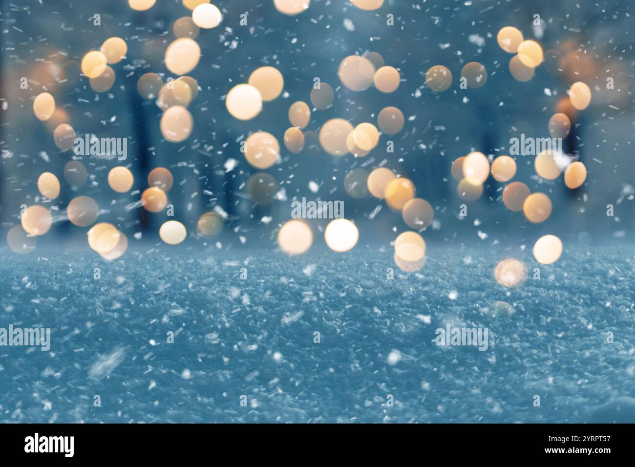 Fantastischer Winterabend mit Schnee und Park mit goldenen Lichtern Bokeh. Neujahr und Weihnachten, Hintergrund der Winterferien. Magisches Winterwetter Stockfoto