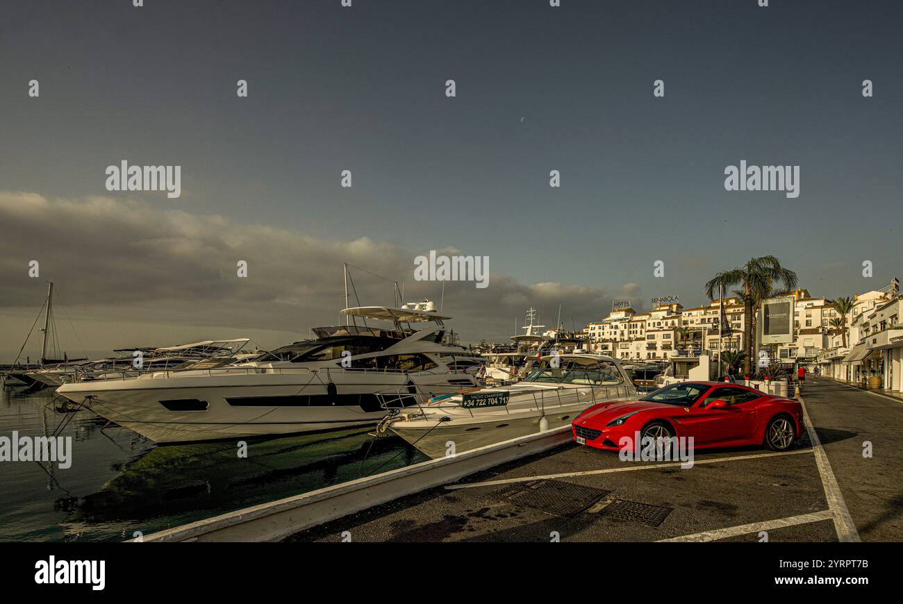 Luxusgeschäfte in der Calle Ribera, Sportwagen, Mega-Yachten im Hafen und weiße Häuser, Puerto Banús, Marbella, Costa del Sol, Spanien Stockfoto