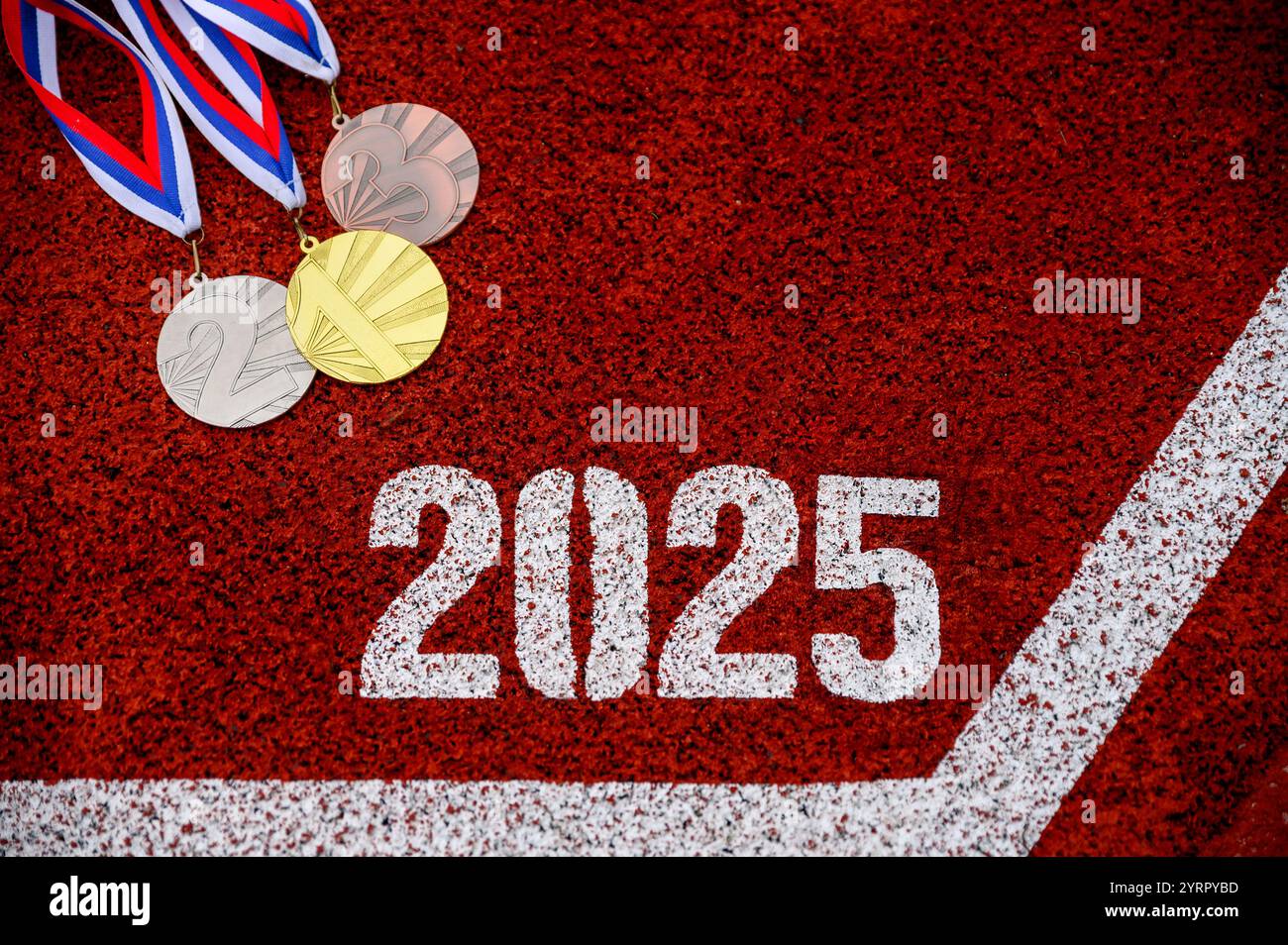 Motivation für das neue Jahr 2025. 2025 auf der roten Laufbahn und Medaillensatz auf der Rennstrecke. Preis für Gold, Silber und Bronze Stockfoto