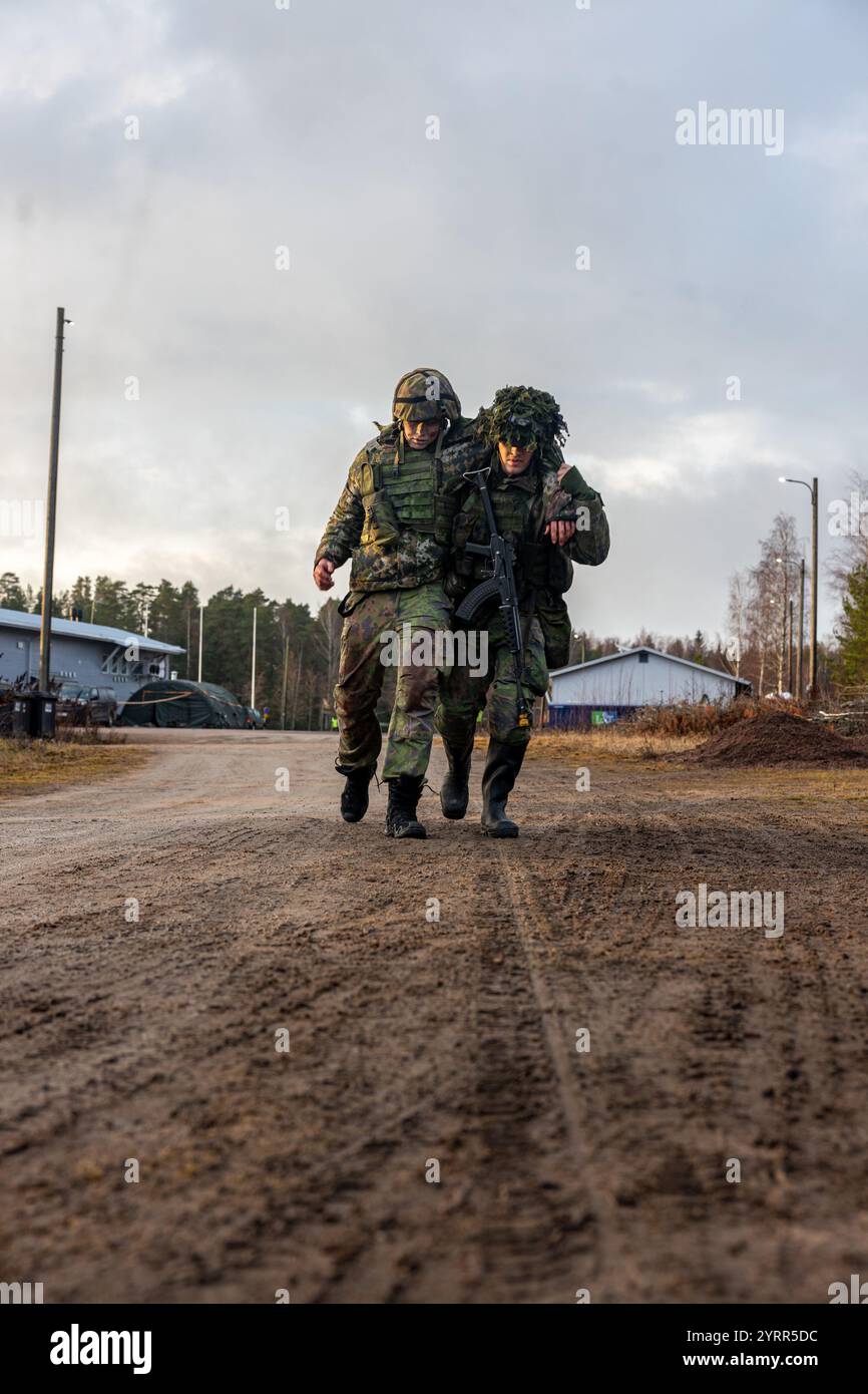 Ein finnisches Dienstmitglied der Küstenbrigade, finnische Marine, hilft einem simulierten Unfall im Zelt während der Übung Freezing Winds 24 in Virolahti, Finnland, 27. November 2024. US-Marines, die der Marine Rotational Force – Europe zugewiesen sind, nehmen in Finnland an der Übung Freezing Winds 24 Teil, einer jährlichen von Finnland geführten maritimen Übung, die als Veranstaltungsort dient, um die Bereitschaft und Interoperabilität der finnischen Marine zwischen NATO-Partnern und Verbündeten in und um die Ostsee zu verbessern. (Foto des U.S. Marine Corps von Lance CPL. Christian Salazar) Stockfoto