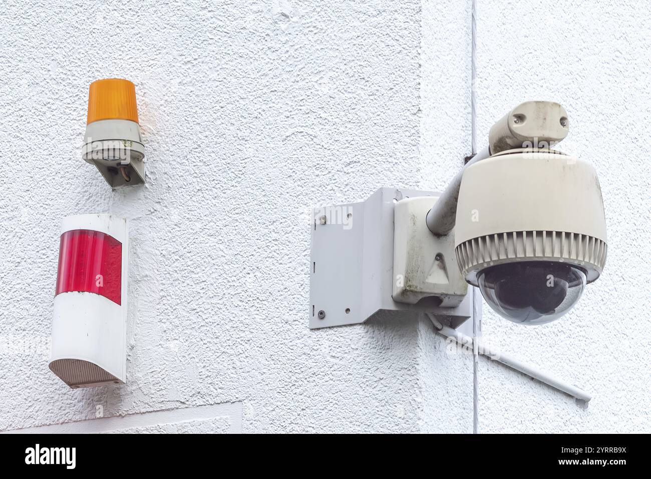 Überwachungskamera mit Warnleuchte an der Hauswand Stockfoto