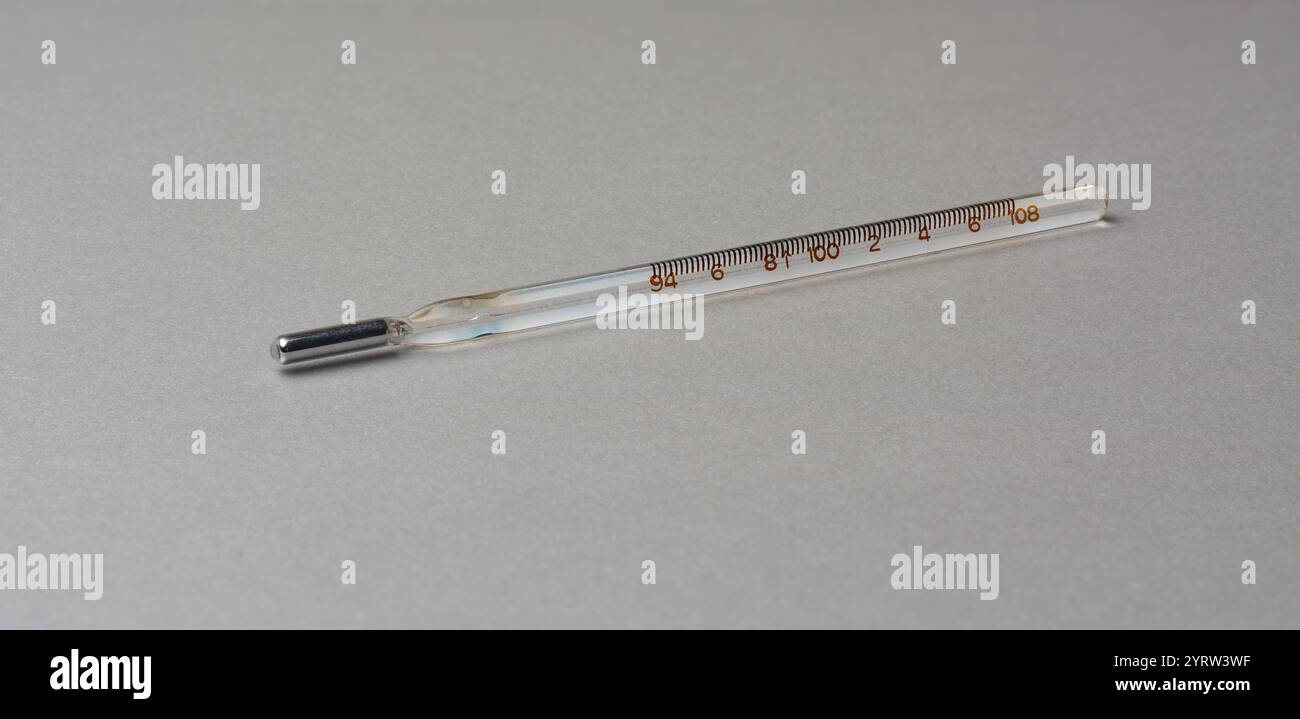 Quecksilberthermometer isolierter strukturierter grauer Hintergrund, klassisches Gerät zur Temperaturmessung mit Glasröhre und Silberkugel, Markierungen Fahrenheit Stockfoto