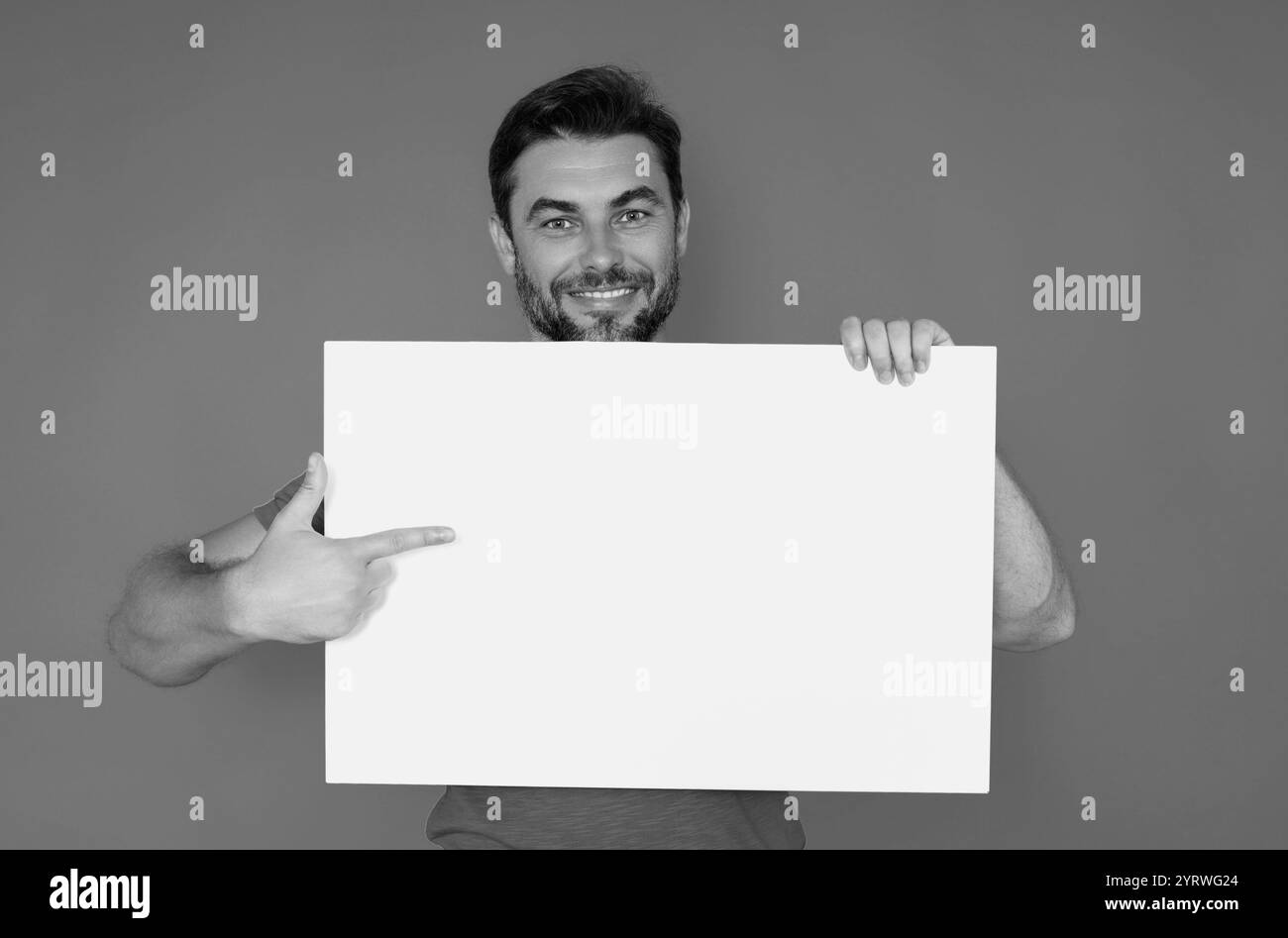 Der Mann hält ein Schild mit Kopierraum. Plakette bereit für Kopierraum Produkt. Melden Sie sich für Ihren Text im Kopierbereich an. Mann mit leerem Schild auf Studiohintergrund. Stockfoto