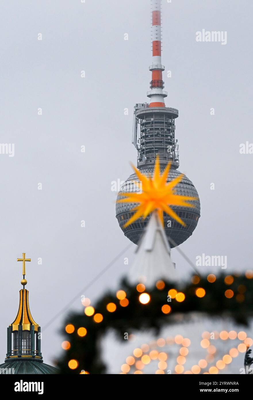 Berlin, Deutschland. Dezember 2024. Vor dem Fernsehturm und der Spitze des Doms ist ein beleuchteter Weihnachtsstern vom Weihnachtsmarkt am Bebelplatz zu sehen. Quelle: Jens Kalaene/dpa/Alamy Live News Stockfoto