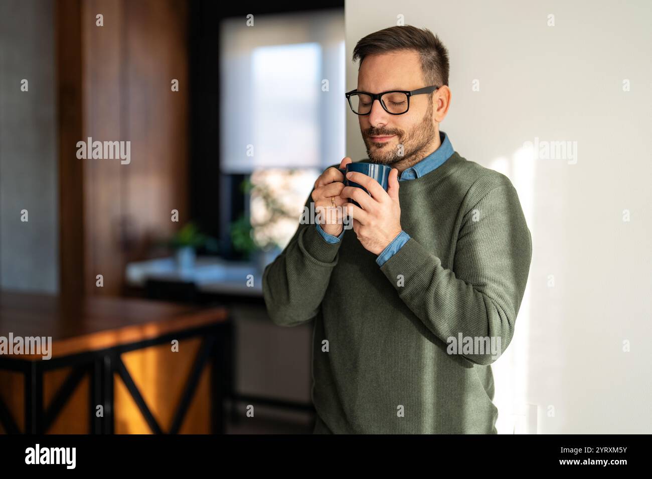 Porträt eines glücklichen erfolgreichen ausgewogenen Mannes, der lacht, die kleinen Dinge im Leben genießt. Trinkt Kaffee Stockfoto