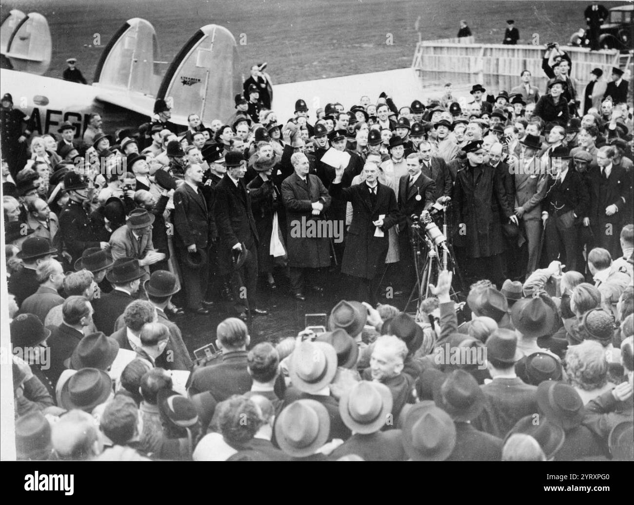 Der britische Premierminister Neville Chamberlain kehrt aus München zurück und erklärt "Frieden in unserer Zeit". Das Münchner Abkommen wurde am 30. September 1938 von Deutschland, Großbritannien, der Französischen Republik und Italien geschlossen. Das Abkommen sah die deutsche Annexion eines Teils der Tschechoslowakei vor, das Sudetenland, in dem mehr als drei Millionen Menschen lebten, hauptsächlich ethnische Deutsche. Stockfoto