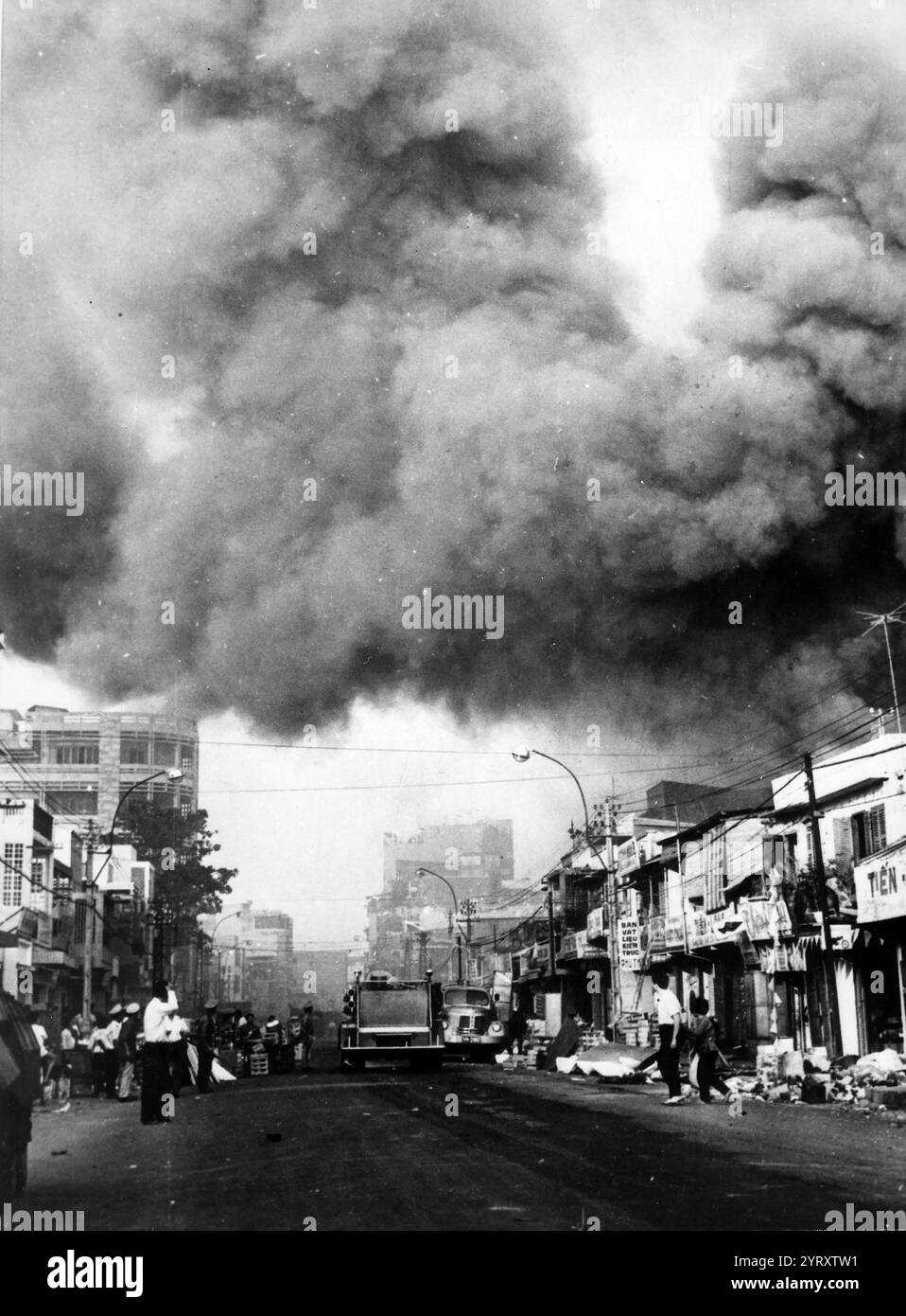 Schwarzer Rauch bedeckt Bereiche der Hauptstadt, und Feuerwehrfahrzeuge stürzen sich zu den Orten der Brände, die während der festlichen Tet-Feiertage durch die Viet Cong ausgelöst wurden. Saigon, 1968 Stockfoto