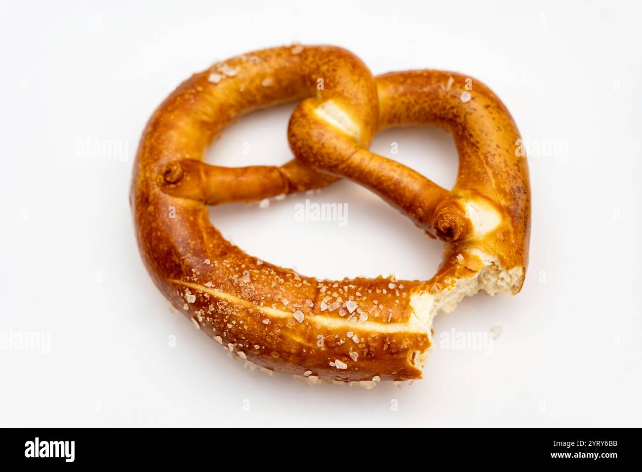Rohes Salz auf einer frisch gebackenen Brezel Stockfoto