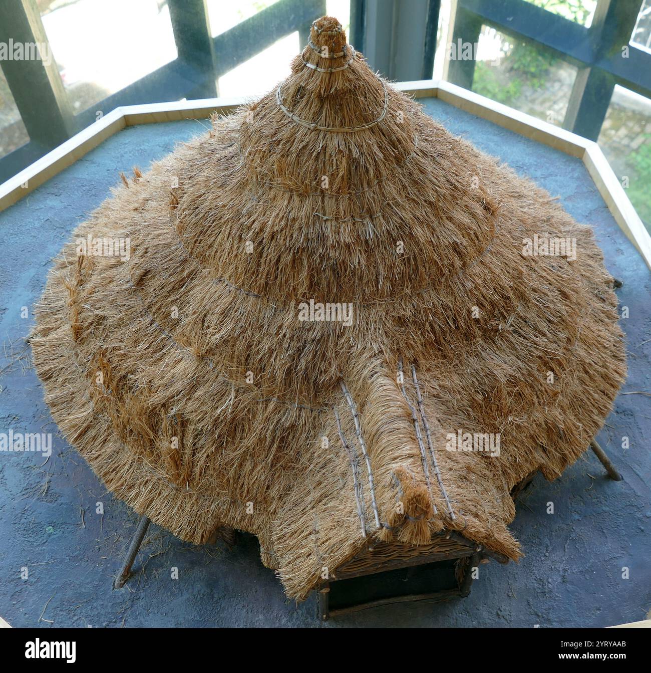 Modell eines Eisenzeit-Kreishauses, das 1960 in Pimperne, Dorset, England ausgegraben wurde Pimperne ist ein Dorf aus sächsischer Zeit, das im Domesday Book (1086) als „Pinpre“ erwähnt wird. Das Dorf steht in einem Tal und liegt größtenteils auf Kreide. Eine eisenzeitliche Siedlung auf dem Hügel hinter der Kirche stammt aus der Zeit um 500 v. Chr., während die Long Barrow an der nördlichen Grenze des Dorfes möglicherweise 4000 Jahre alt ist. Stockfoto