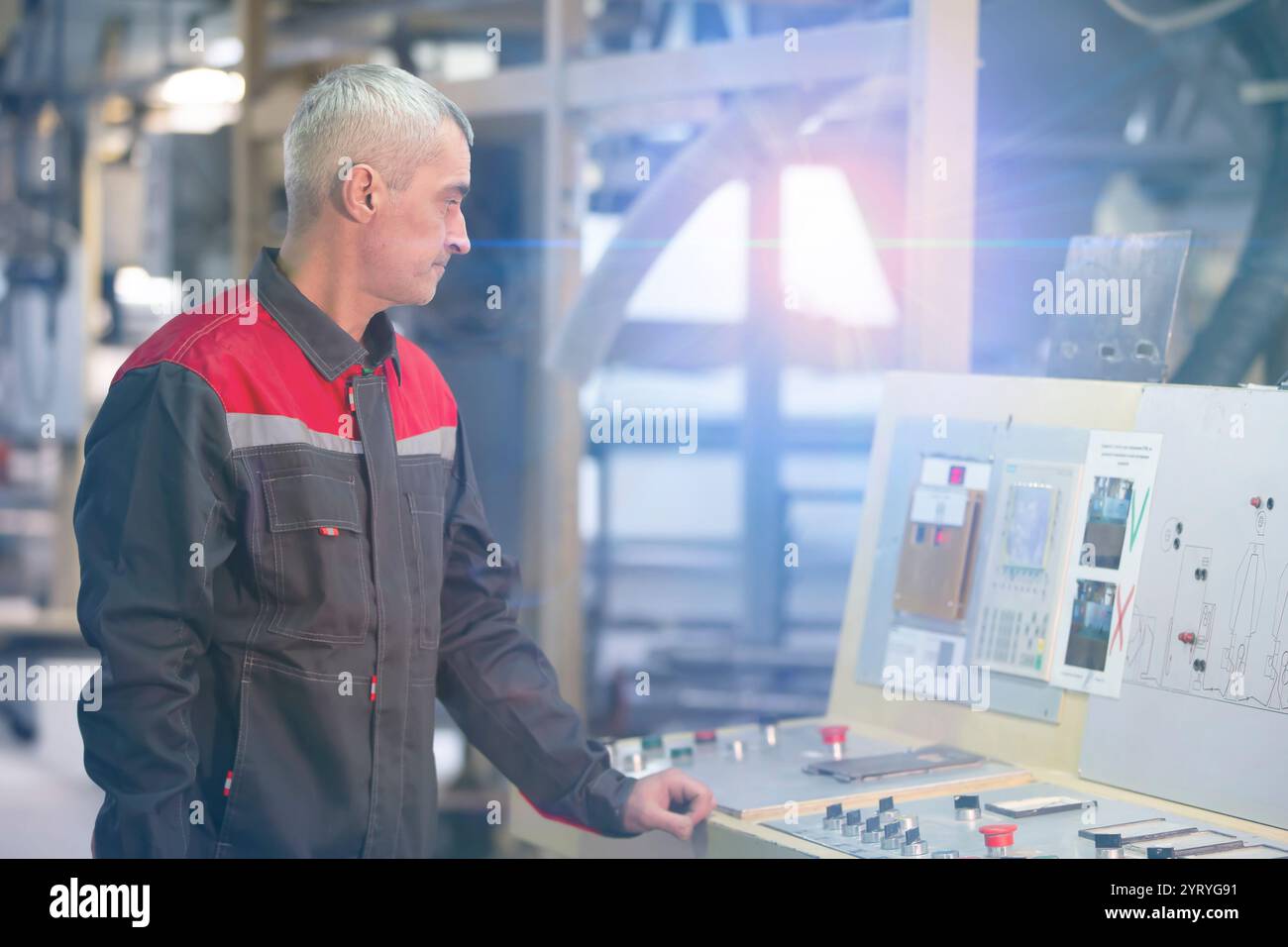 Ein Mitarbeiter in einem Unternehmen an einer computergesteuerten Maschine. Stockfoto