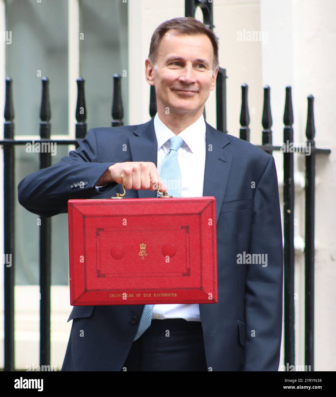 Der britische konservative Kanzler Jeremy Hunt steht mit seinem roten Koffer, als er von der Downing Street in London zum Parlament reist, um den Frühjahrshaushalt im März 2024 zu liefern. Stockfoto