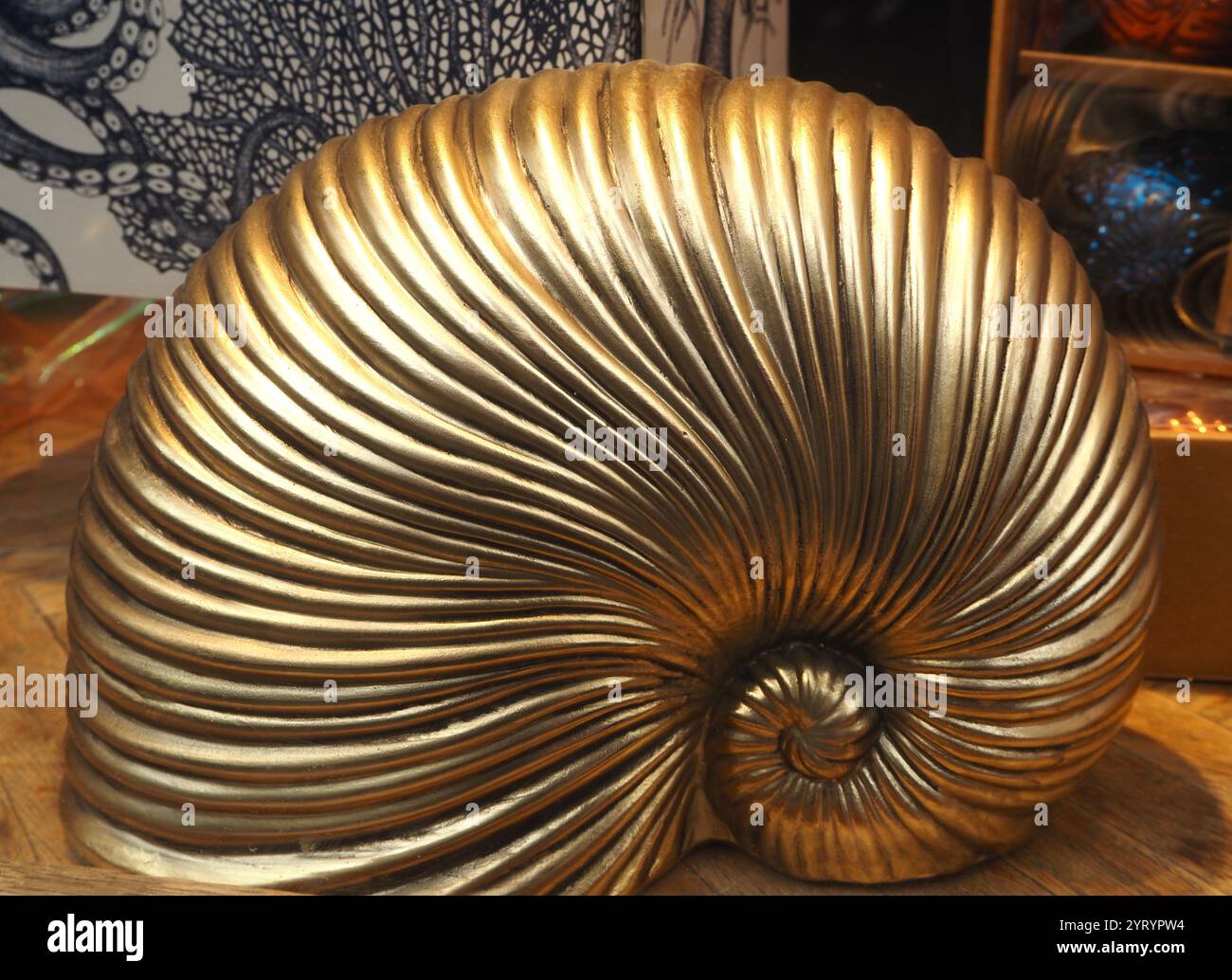 Goldene, spiralförmige, gerippte Schneckenschalen-Skulptur Stockfoto