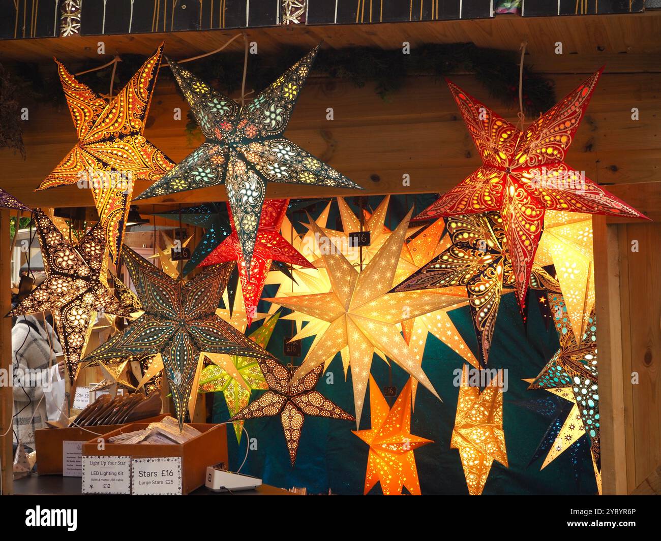 Große beleuchtete Sterne, die von Paperstarlights für Weihnachtsdekorationen auf dem Bath Christmas Market, Bath, Somerset verkauft werden. Stockfoto