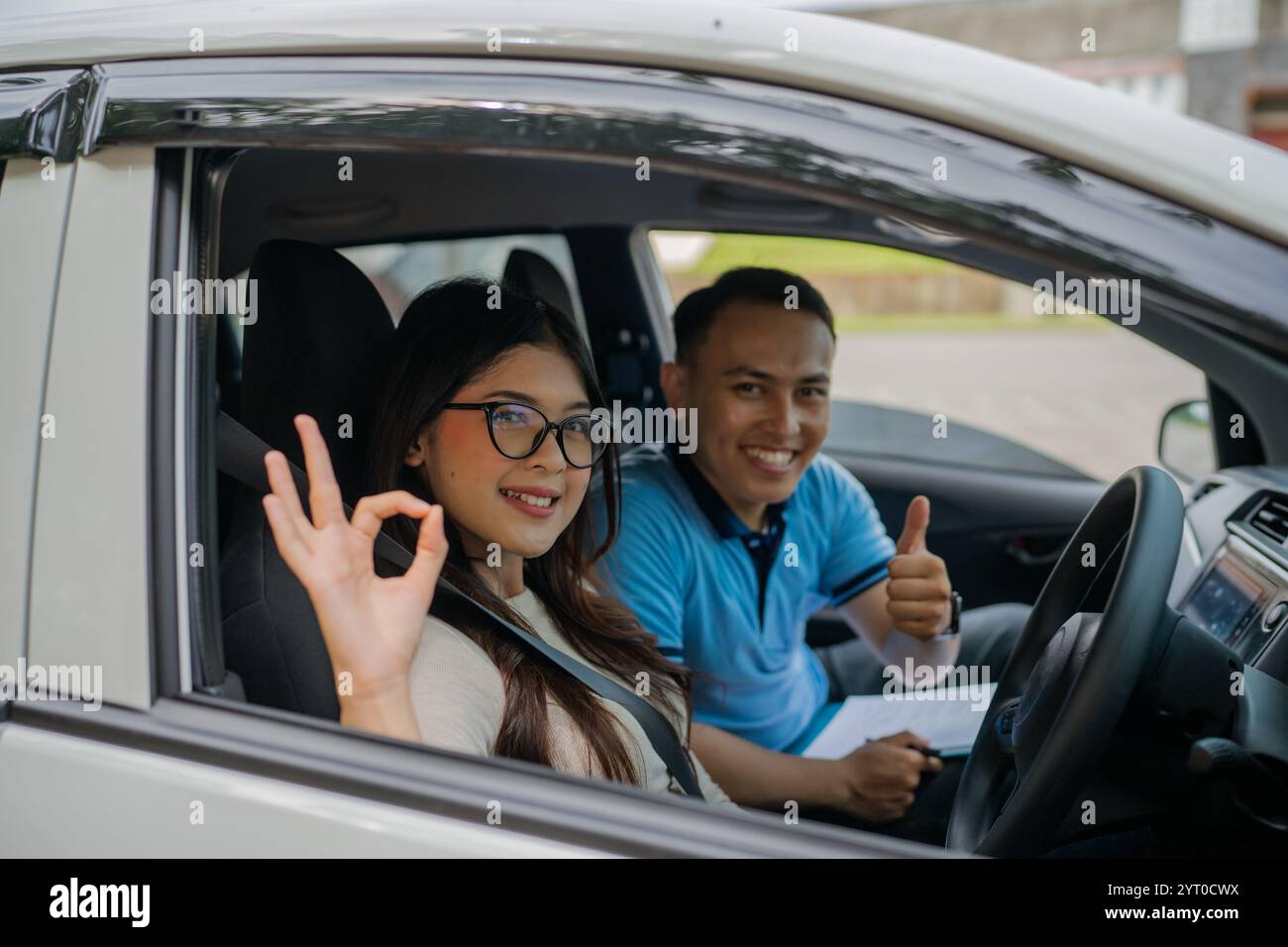 Ein Schüler und ein Kursleiter feiern den erfolgreichen Abschluss einer Fahrstunde Stockfoto