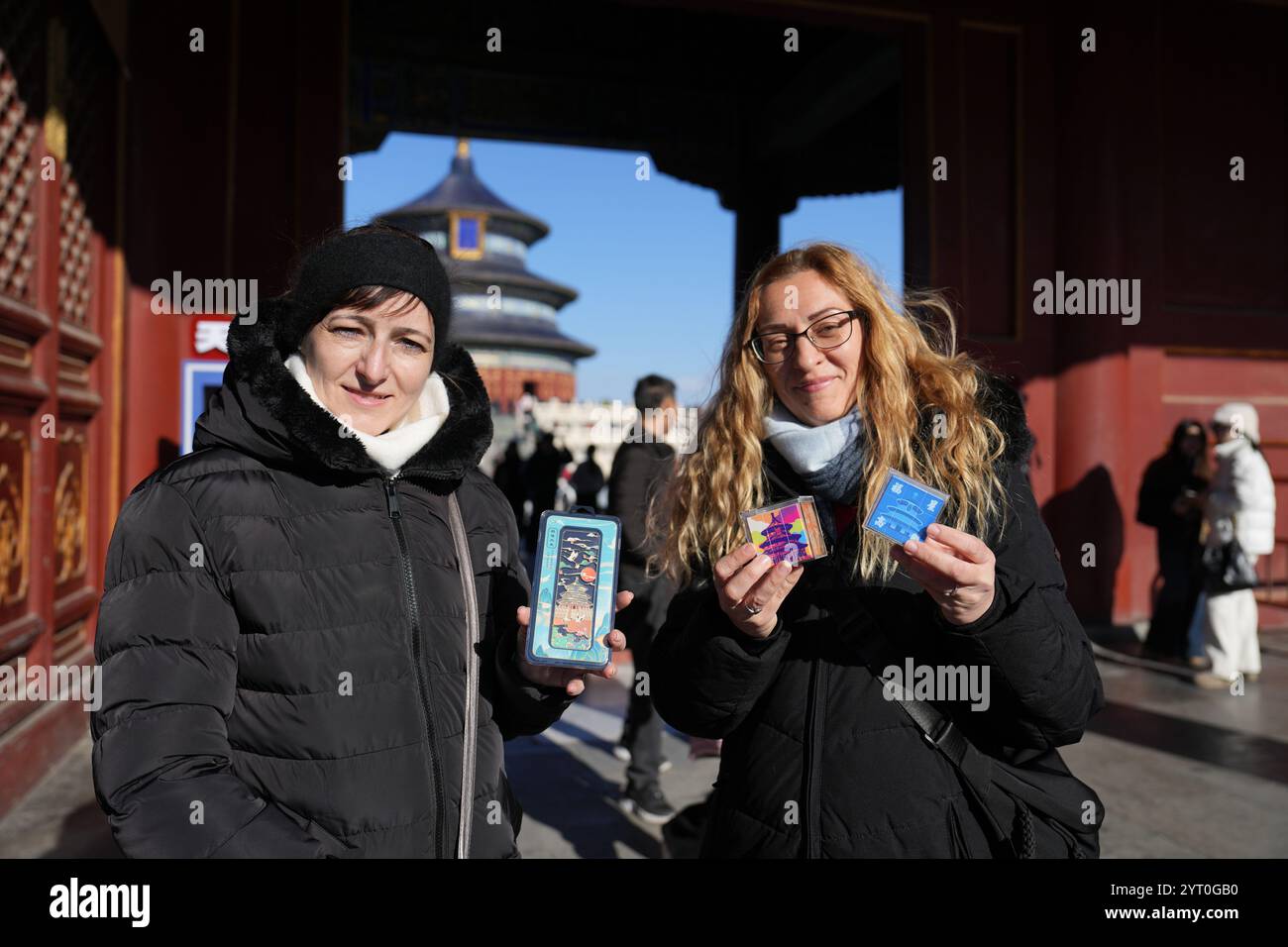 (241205) -- PEKING, 5. Dezember 2024 (Xinhua) -- Touristen aus Ungarn zeigen Souvenirs, die im Tiantan (Tempel des Himmels) Park in Peking, Hauptstadt Chinas, gekauft wurden, 5. Dezember 2024. Die Ausweitung der visafreien Politik ist ein Meilenstein auf Chinas Weg zu größerer Offenheit und zeigt auch sein Vertrauen auf der globalen Bühne. Bisher genießen 38 Länder einseitigen visafreien Zugang, und der maximale Aufenthalt für Besucher wurde ab November 30 auf 30 Tage verlängert. Im dritten Quartal 2024 erreichte die Zahl der Ausländer, die nach China einreisten, 8,186 Millionen, was einem Anstieg von 48,8 Prozent gegenüber dem Vorjahr entspricht. Darunter 4,885 Millionen Entrecht Stockfoto