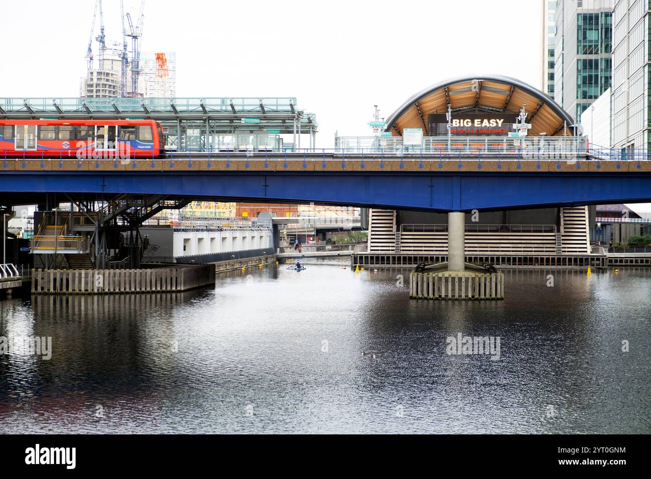 DLR-Zug überquert die Eisenbahnbrücke North Dock und Blick auf das Big Easy Restaurant am Canary Wharf West India Quay East London England 2024 UK KATHY DEWITT Stockfoto