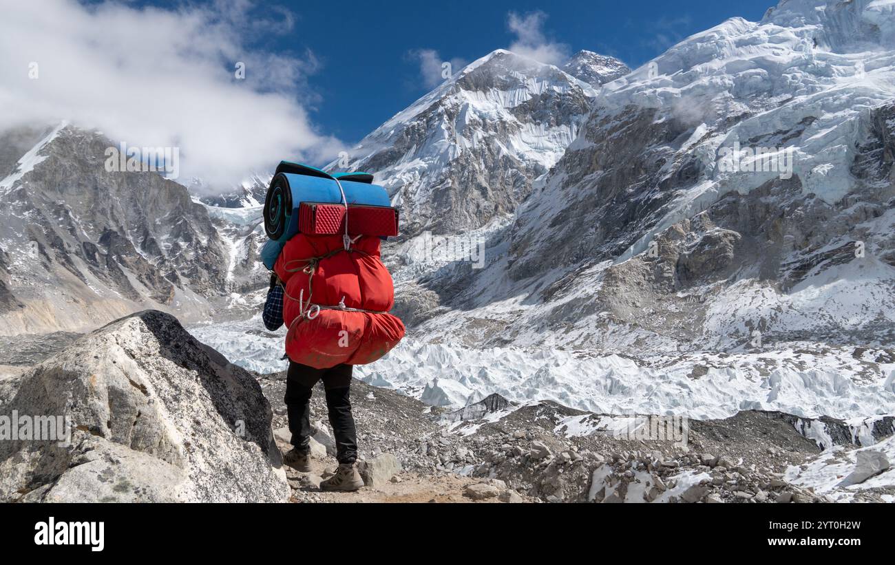 Ein Sherpa-Porter mit Expeditionsausrüstung, der das Mount Everest Base Camp erreicht Stockfoto