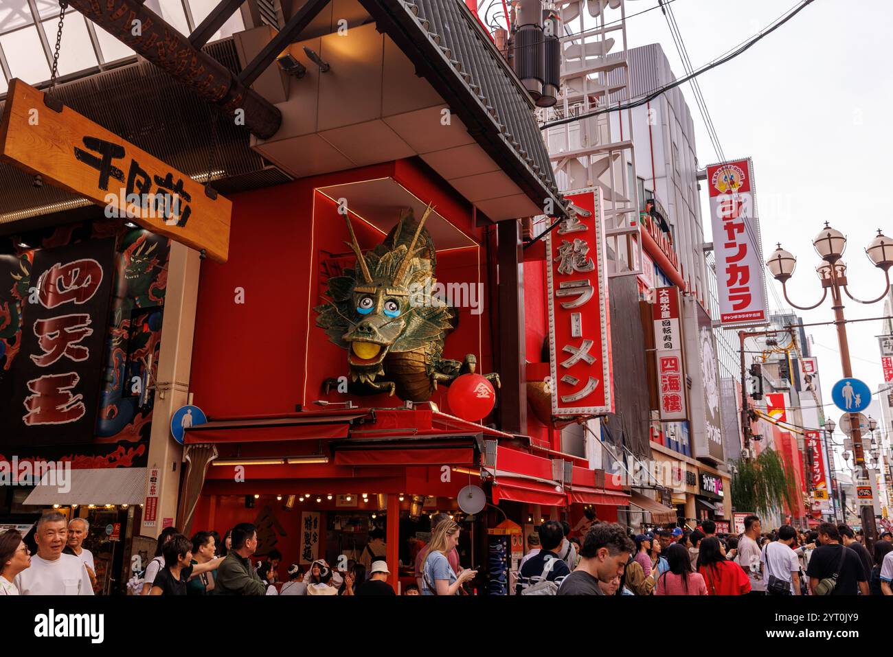 OSAKA, Japan – 25. Oktober 2024: Dotonbori Street in Japan mit einer markanten Drachenskulptur, die sich über einem Ramen-Shop erhebt Stockfoto