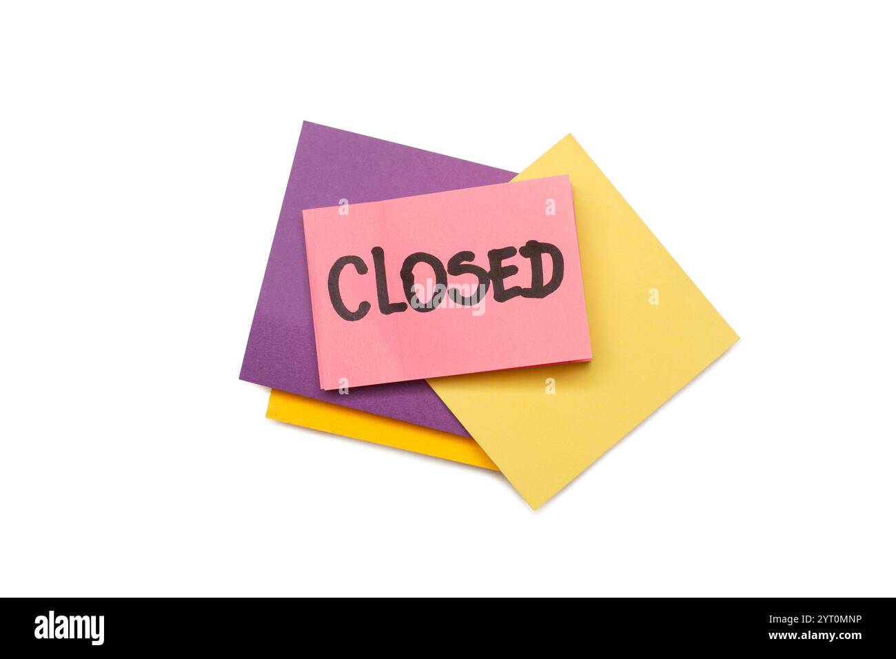 Geschlossenes einzelnes Wort, handgeschrieben auf einer rosafarbenen Klebenotiz auf einem Stapel farbiger Papiernotizen auf weißem Hintergrund Stockfoto