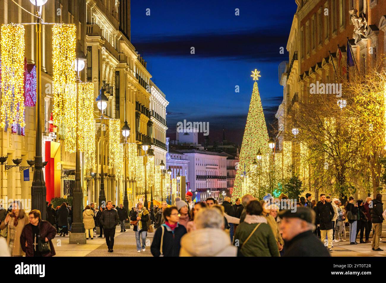 Alcala Straße bei Einbruch der Dunkelheit, beleuchtet von weihnachtslichtern, mit Puerta del Sol Platz im Hintergrund. Madrid, Spanien Stockfoto