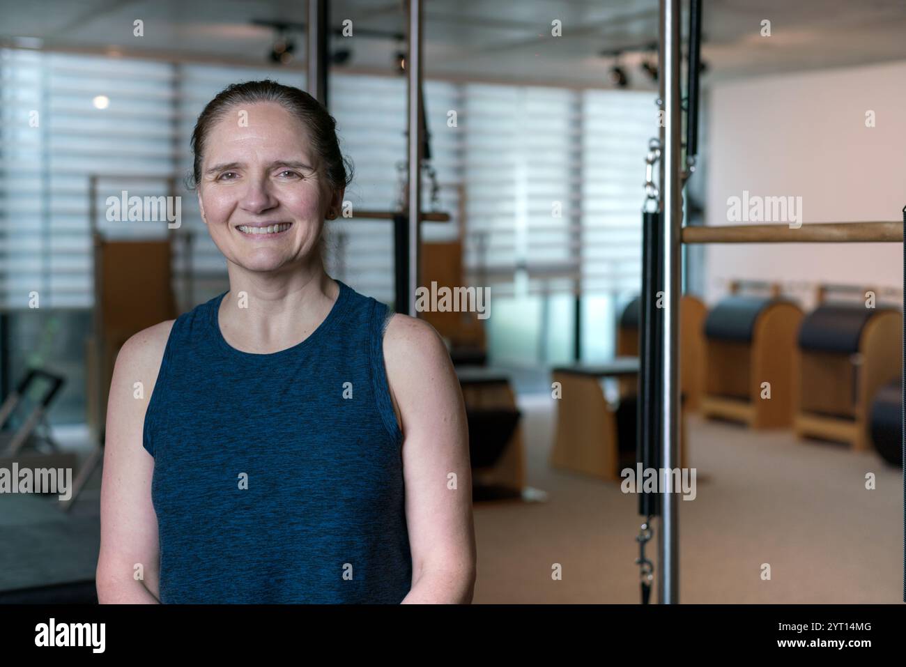Frau mittleren Alters posiert stolz im Pilates-Fitnessstudio. Stockfoto