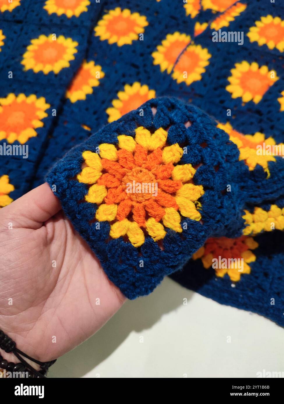 Granny Quadrat häkeln, quadratisches Häkelmuster, gestrickte Muster, gelbe Sonnenblume, blau gestrickte Strickjacke mit Blumenmuster, Bündchen, Blume, Bohemian Stil Stockfoto