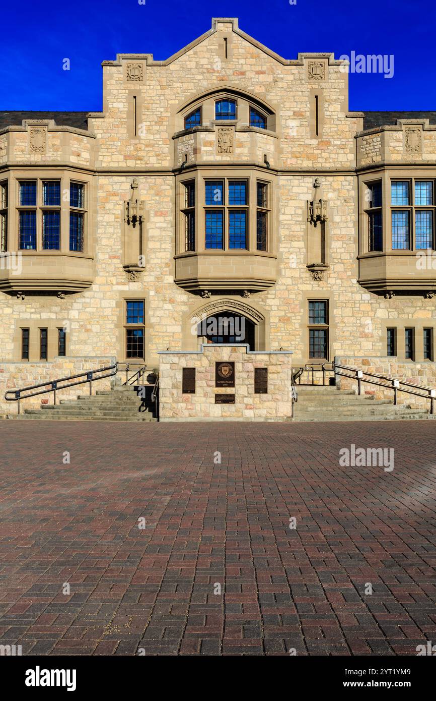 Ein großes Gebäude mit einer Steinfassade und einer Tafel an der vorderen Treppe. Das Gebäude scheint eine Universität oder ein College zu sein Stockfoto