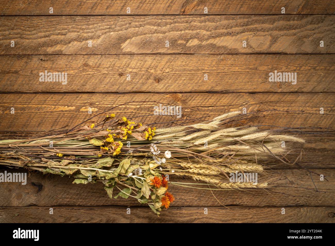 blumenstrauß im Herbst mit getrockneten Blumen und Kornstielen auf rustikalem verwittertem Holz Stockfoto