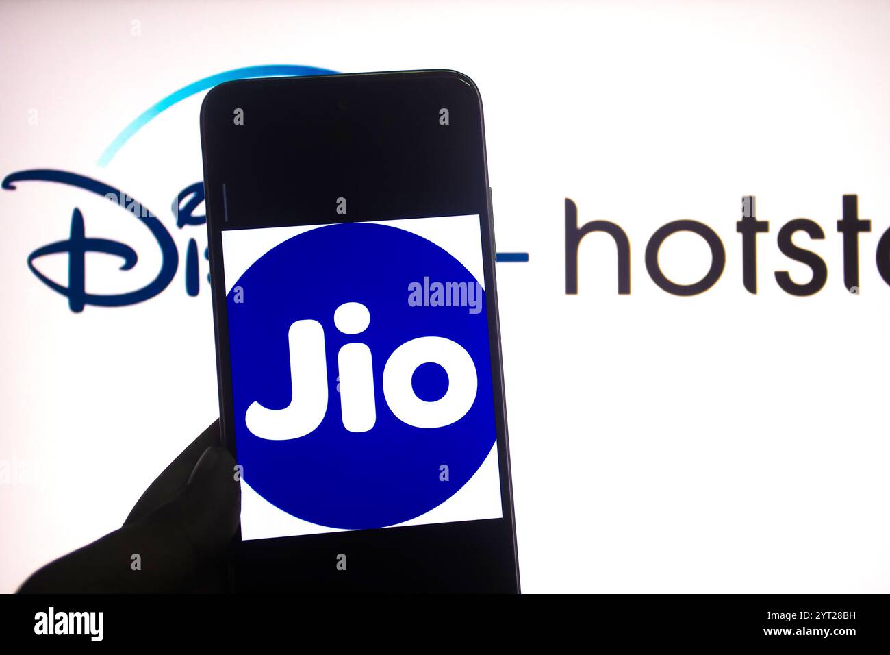 Indien. Dezember 2024. In dieser Fotoabbildung wird ein Reliance JIO Logo auf einem Smartphone mit einem Disney Hotstar Logo im Hintergrund angezeigt. (Credit Image: © Avishek das/SOPA Images via ZUMA Press Wire) NUR REDAKTIONELLE VERWENDUNG! Nicht für kommerzielle ZWECKE! Stockfoto