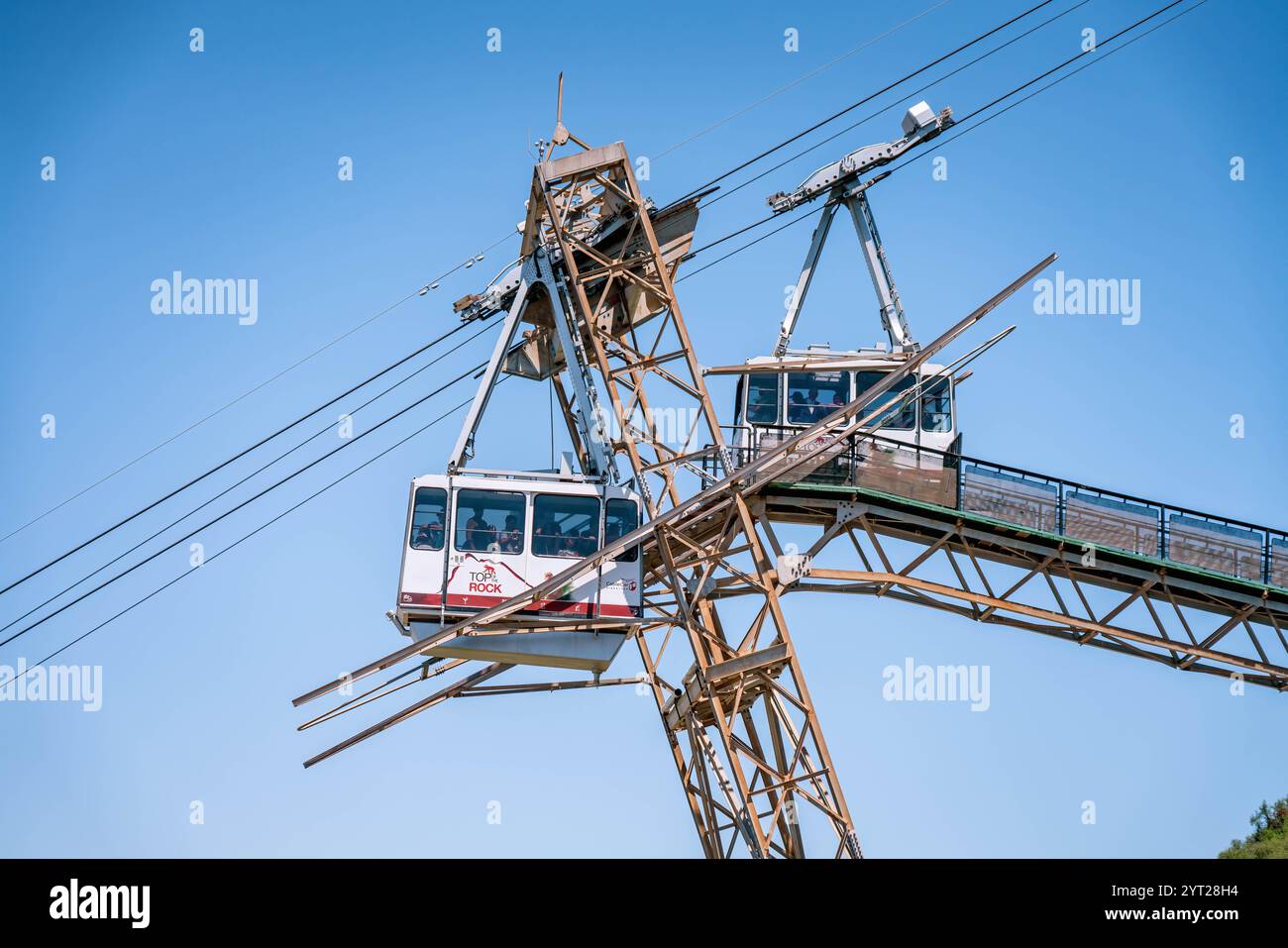 Zwei Seilbahnen, die Touristen transportieren, fahren an einem sonnigen Tag auf dem Weg zur Spitze des Felsenbeobachtungspunkts vorbei Stockfoto