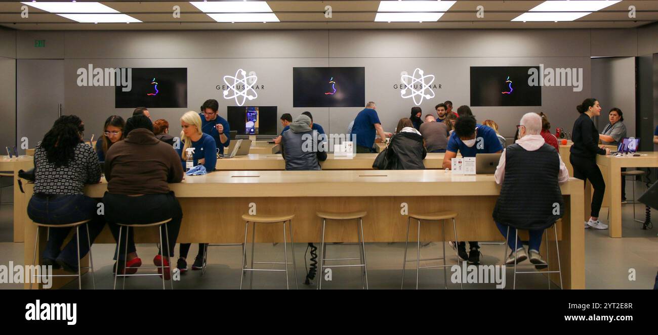 Huntington, New York, USA - 1. Mai 2022: Kunden interagieren mit Mitarbeitern im Einzelhandel in einem Apple Store, während sie elektronische Produkte in einem geräumigen technischen Gerät erkunden Stockfoto