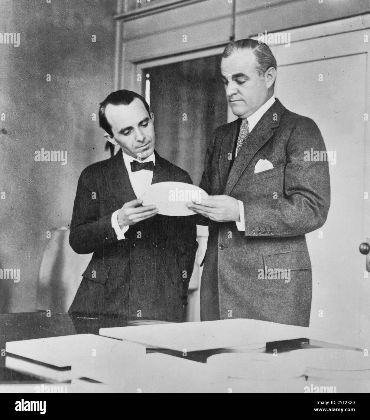 Der Direktor der Münzprägeanstalt Raymond T. Baker und Anthony de Francisci untersuchen das Modell des neuen Silberdollar, dessen erstes am 1. Januar 1921 ausgegeben wird Stockfoto