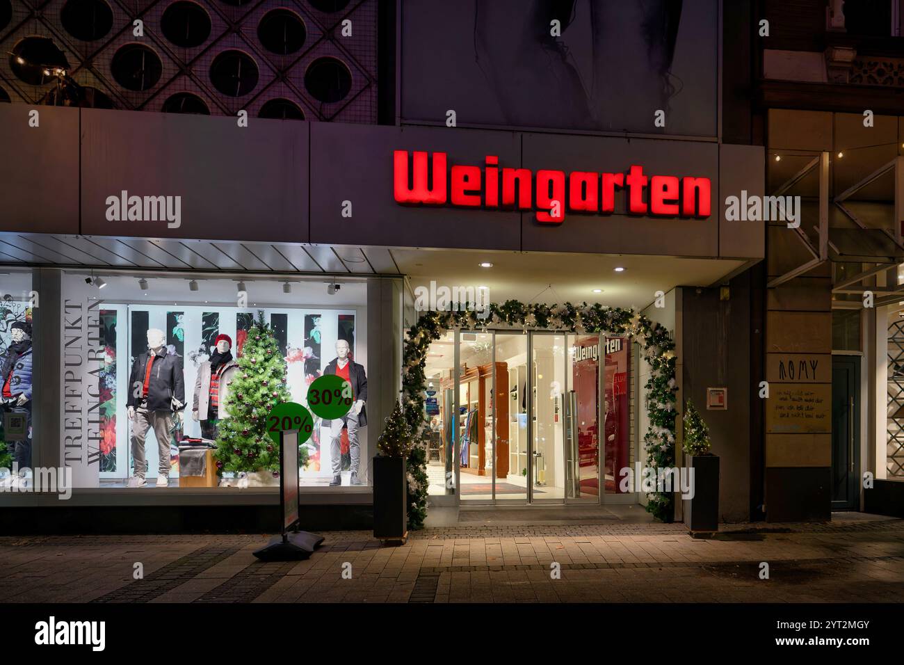 Köln, 4. Dezember 2024: Eingangsbereich mit Leuchtwerbung des traditionsreichen kölner Modehauses Weingarten auf friesenplat Stockfoto