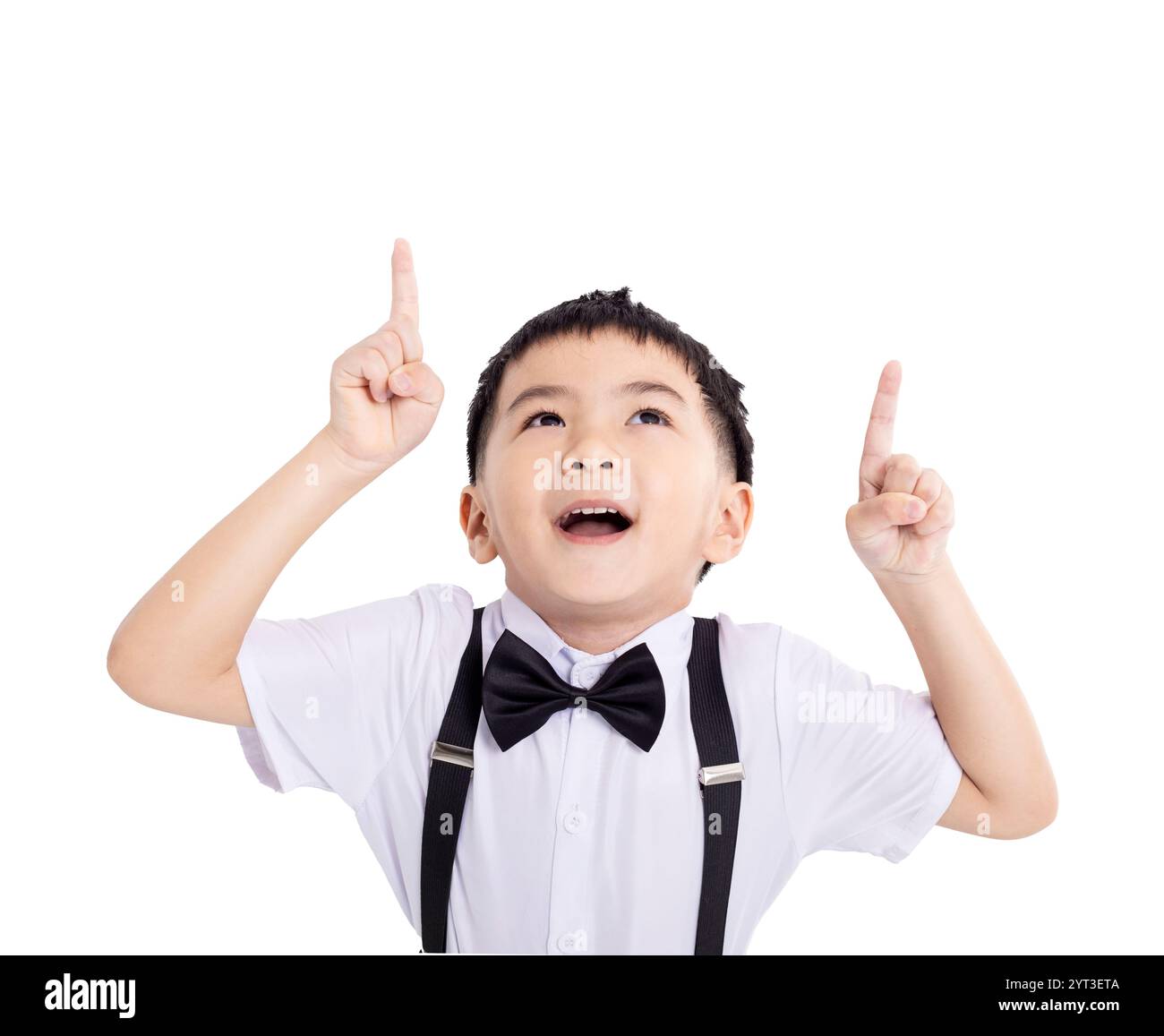 Porträt des verblüfften, süßen Schuljungen, der auf einen leeren Platz auf weißem Hintergrund zeigt Stockfoto