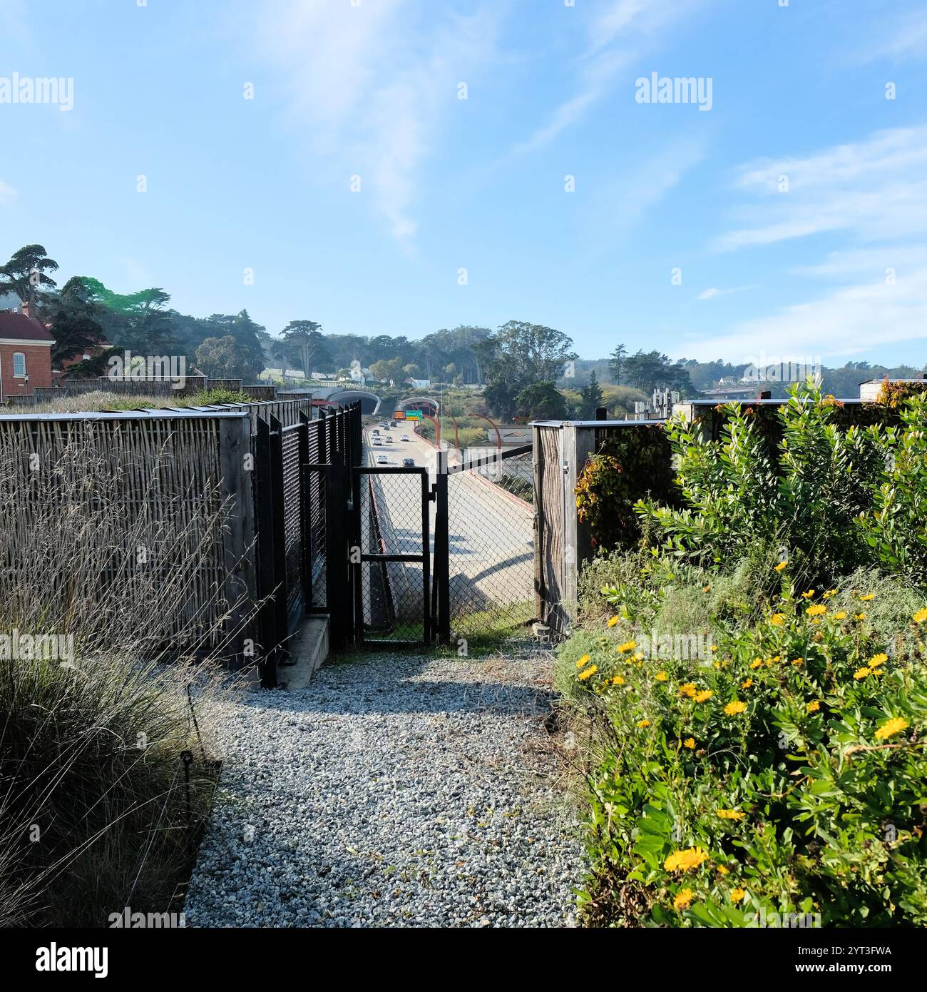 Eingezäunter Zaun mit Blick auf den Highway 101, der sich den Presidio Parkway Tunneln nähert, von den Tunnel Tops Parks aus gesehen, dem Presidio, San Francisco, Kalifornien. Stockfoto
